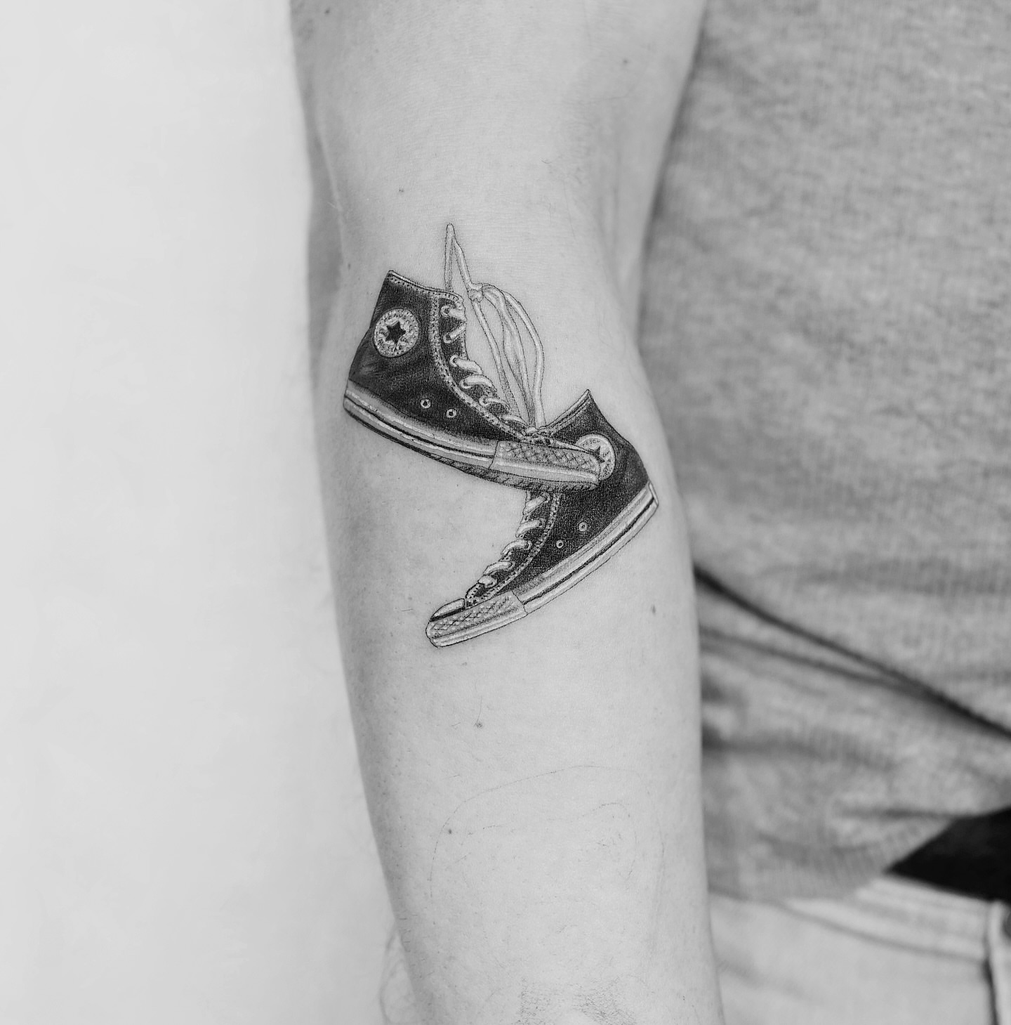 Converse sneakers black and grey tattoo on the forearm by Ross Clark Tattoos