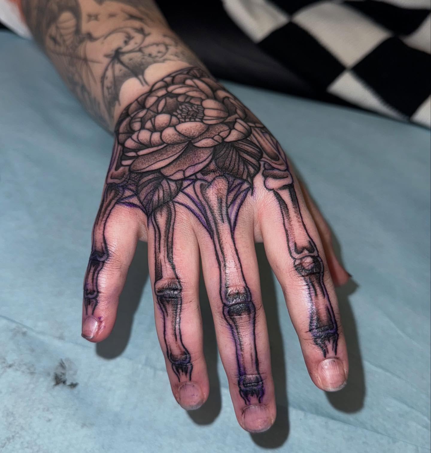 Skeleton hand with floral design realism tattoo on the hand by Laurito