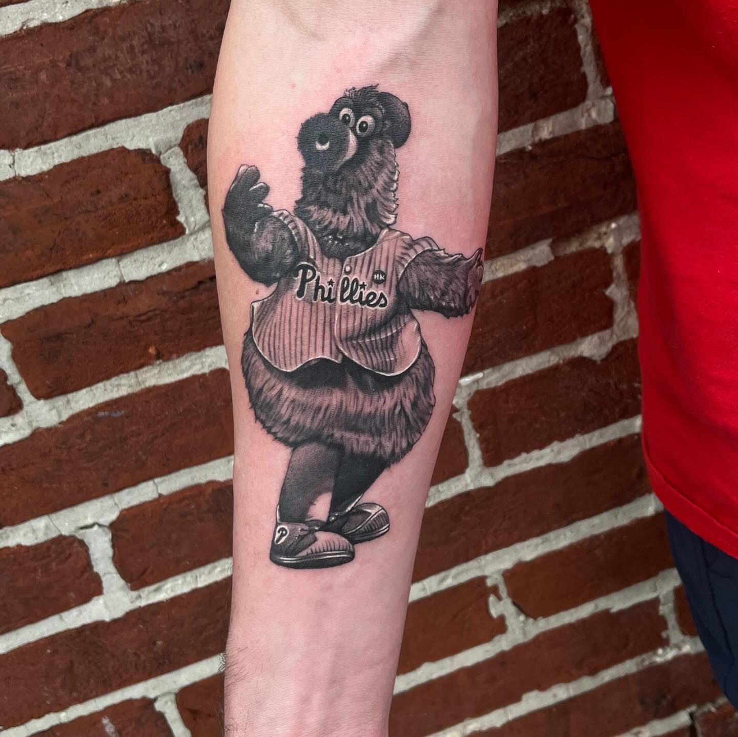 Phillies mascot black and grey tattoo on the forearm by Adam Habecker