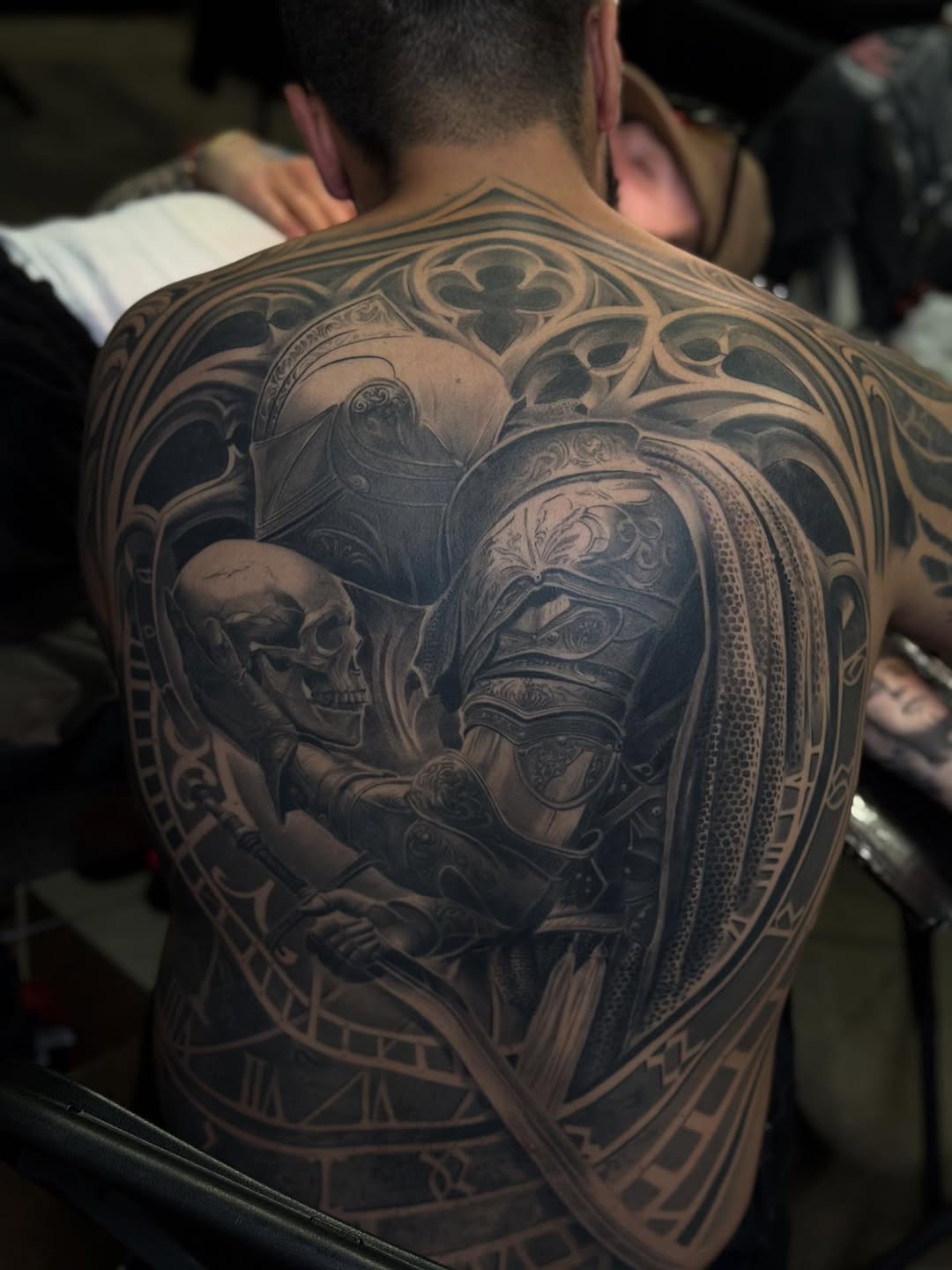 Knight holding a skull realism tattoo on the back by Fabiano Nogarolli, Miami, Florida