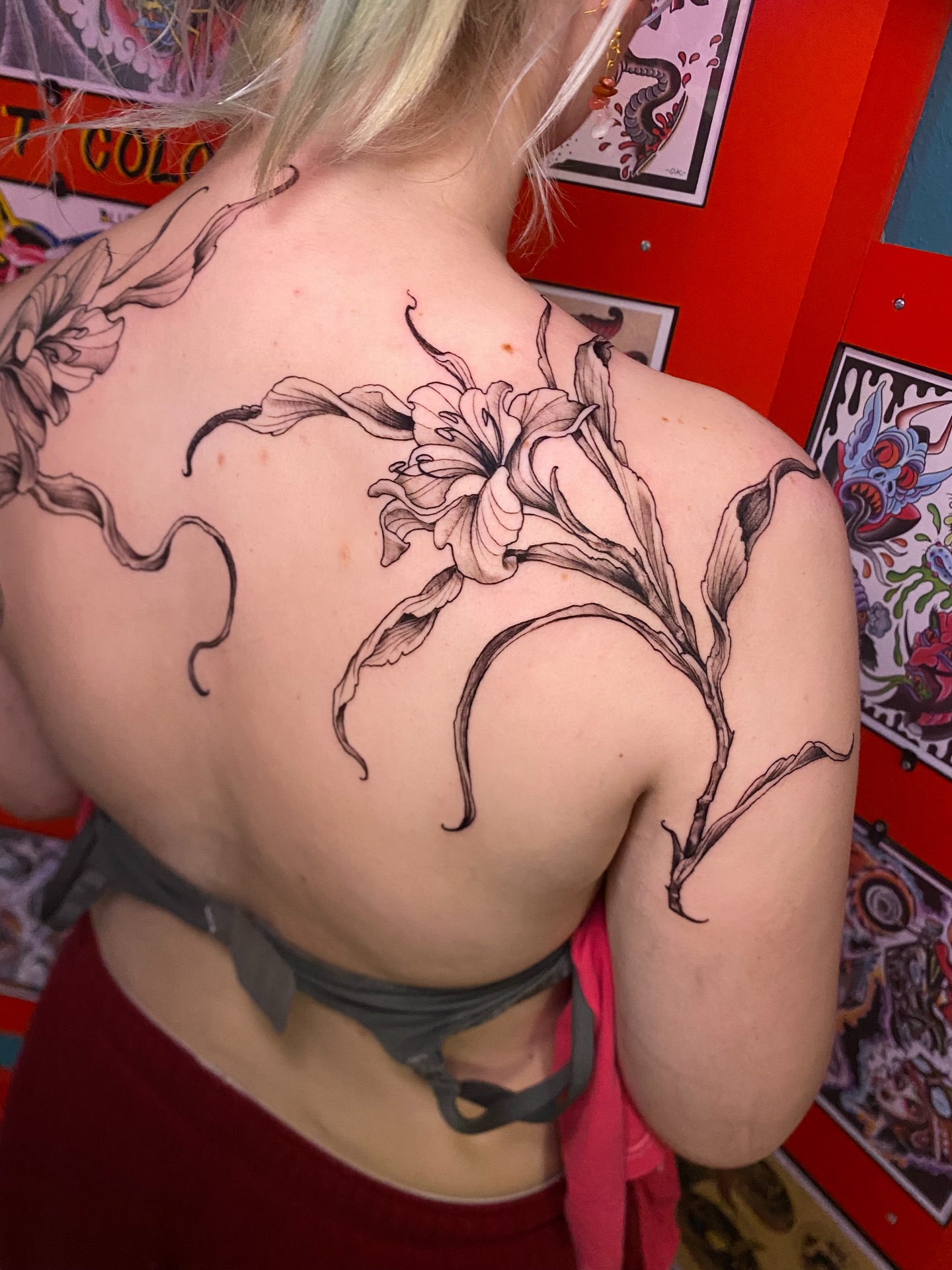 Lily black and grey tattoo on the back by Adam Newton