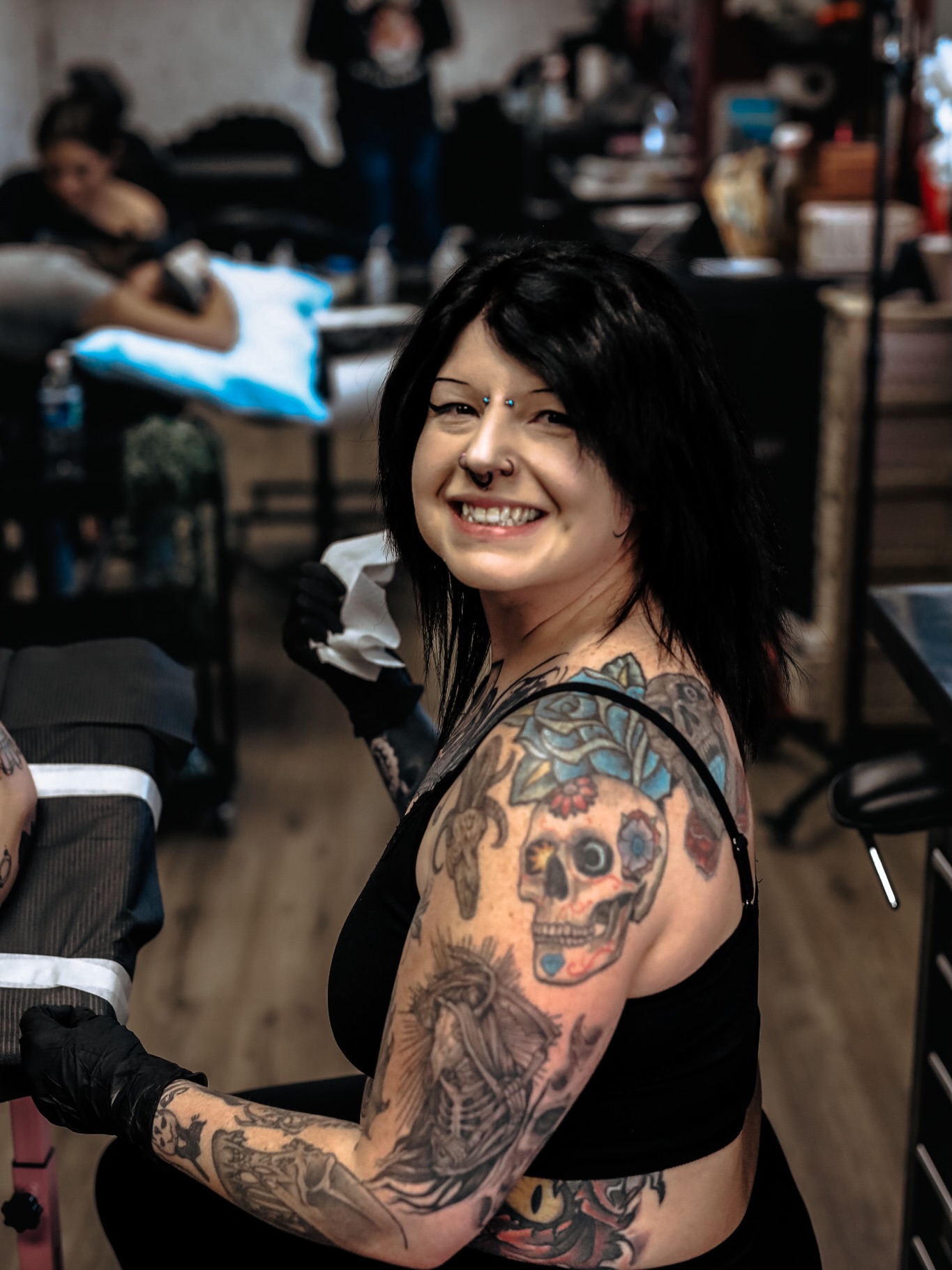 Skull and flowers American traditional tattoo on the upper arm by Jessica π