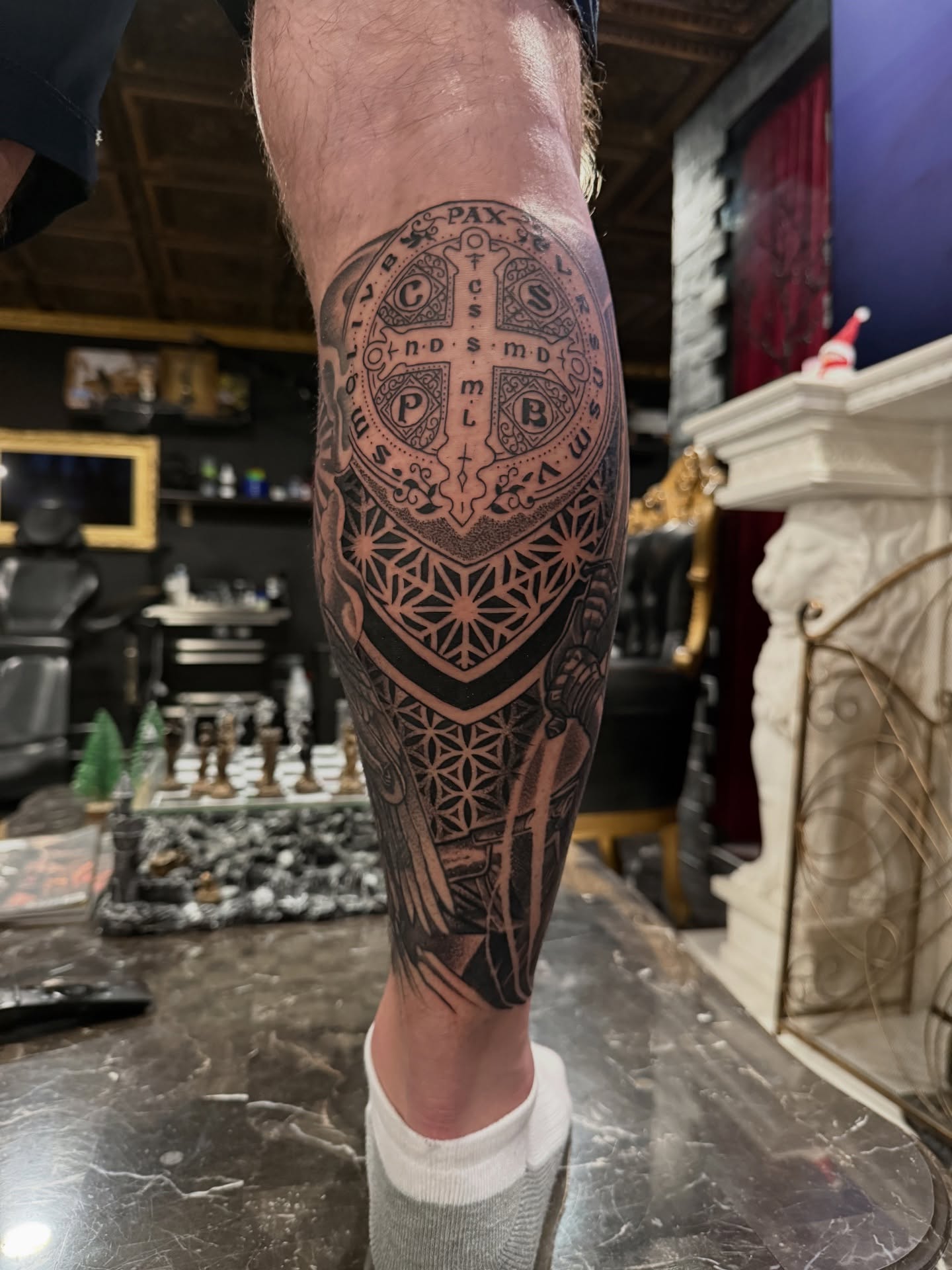 Religious symbol geometric tattoo on the calf by Juan Carlos