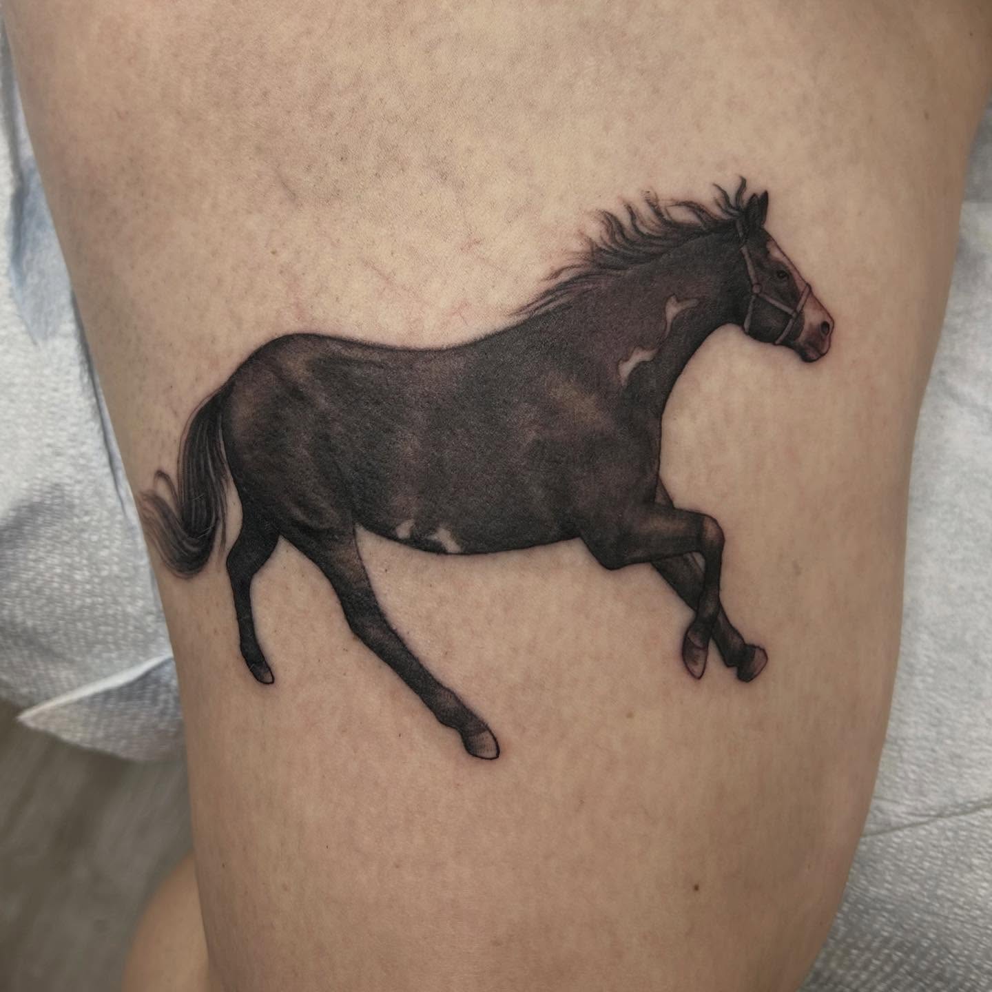 Galloping horse realism tattoo on the thigh by Mary Rose Heckle
