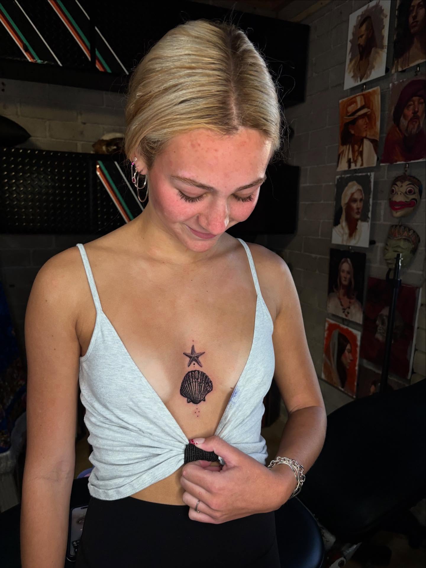 Shell and star black and grey tattoo on the chest by Misty Locket Realism Tattoo Artist Cover-up
