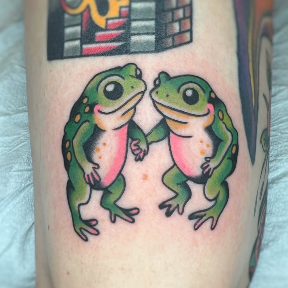 Two frogs American traditional tattoo on the forearm by Cori James Tattoo Artist
