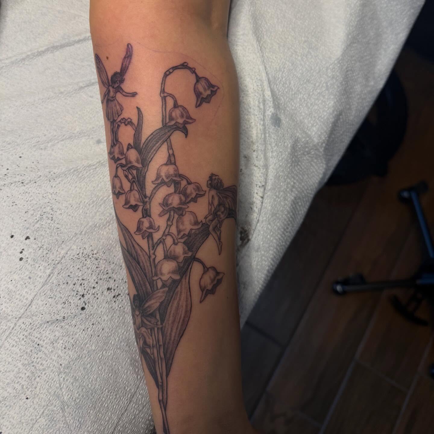 Lily of the valley and fairies black and grey tattoo on the forearm by Cort Prescott 🕸 OKC Tattoo Artist, Oklahoma City, Oklahoma