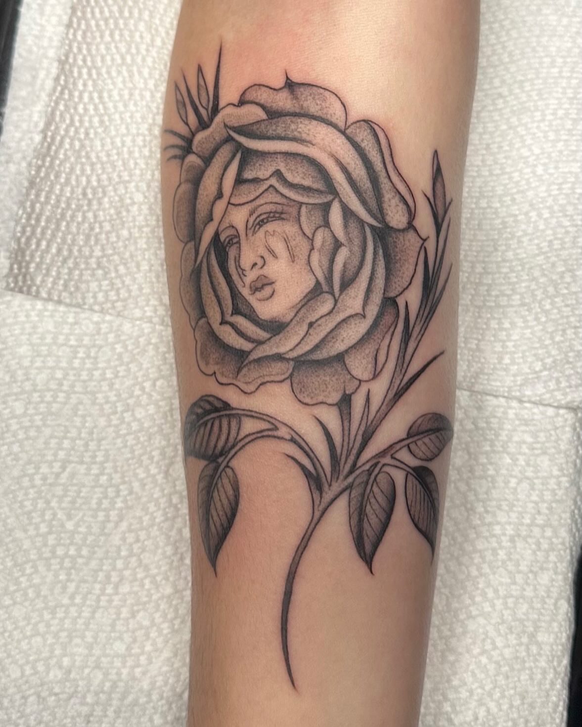Rose with woman's face dotwork tattoo on the forearm by Lia Massari