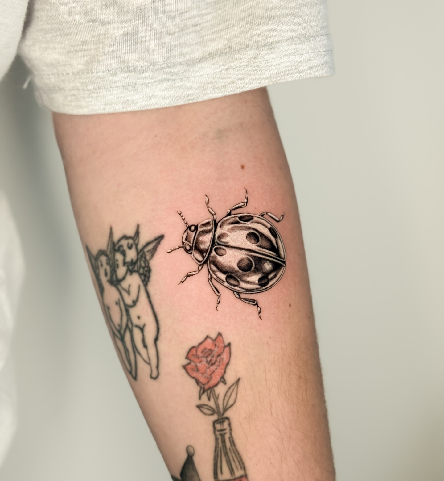Ladybug and rose black and grey tattoo on the forearm by Miami Tattoo Artist, Miami, Florida