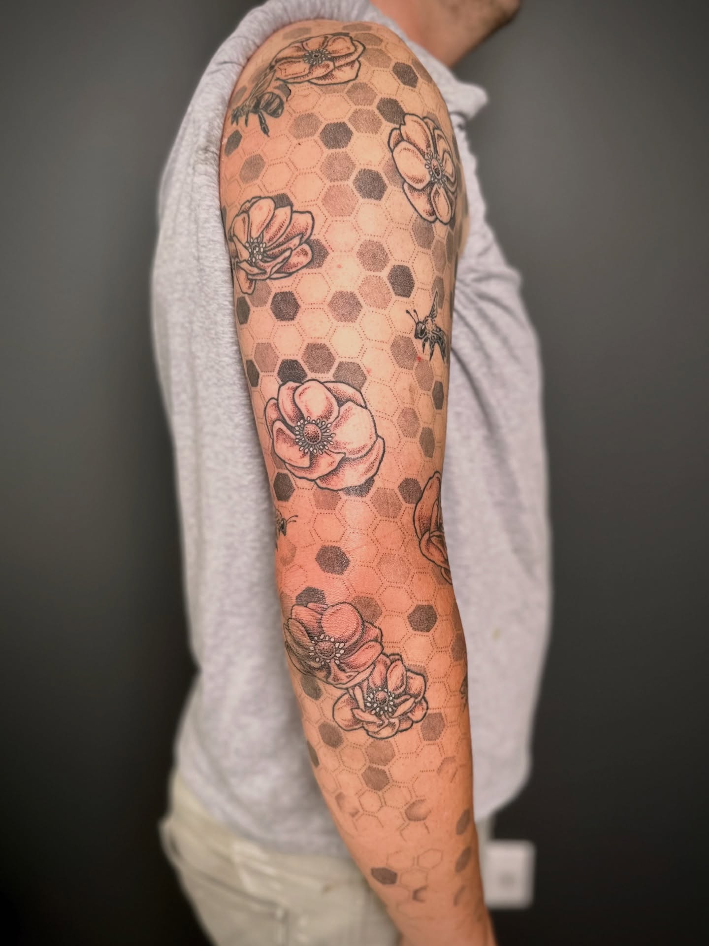 Hexagon pattern with flowers dotwork tattoo on the forearm by Maddie Morrill