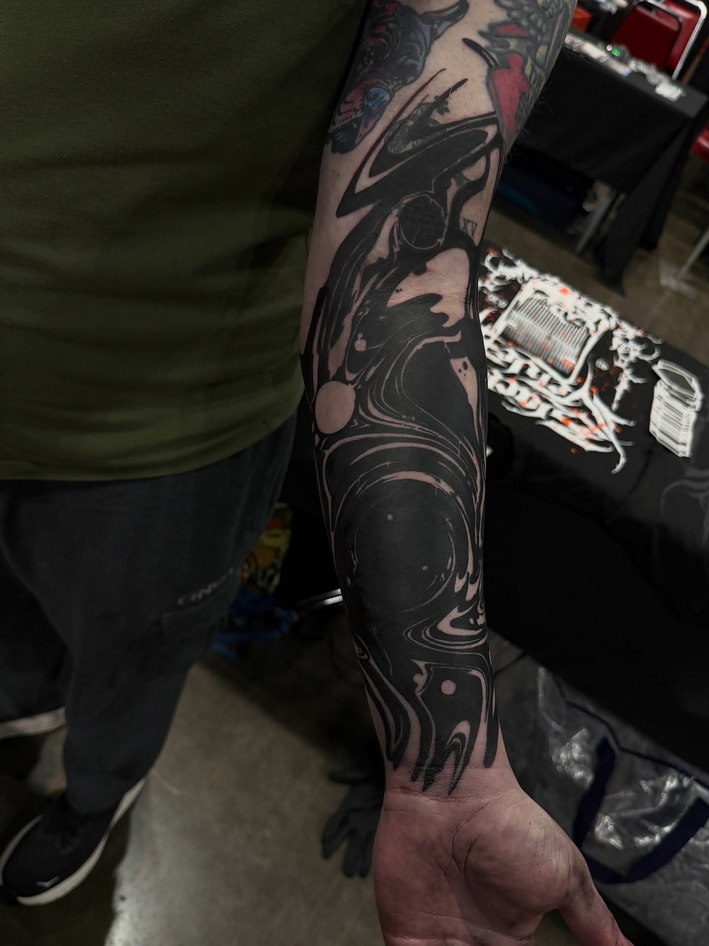 Abstract cosmic scene black and grey tattoo on the forearm by Denver Blackout Tattoo Specialist - Anthony
