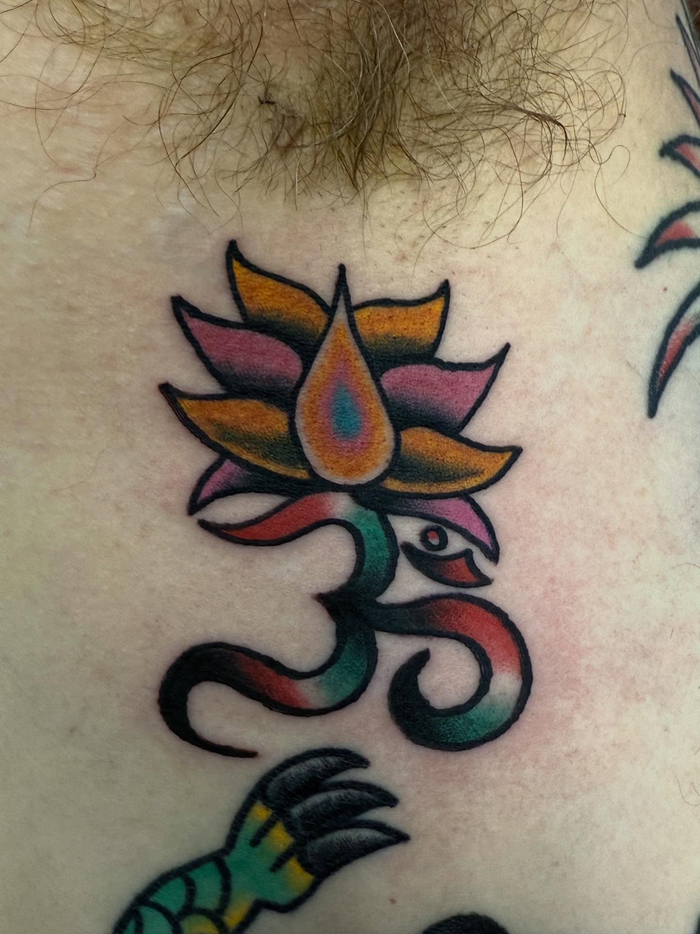 Lotus flower and om symbol American traditional tattoo on the chest by Jesse Coldiron