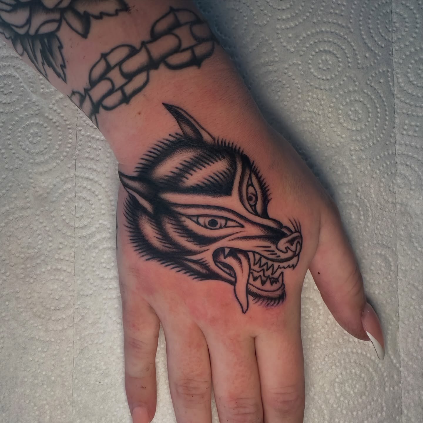 Wolf head black and grey tattoo on the hand by Max Peterson