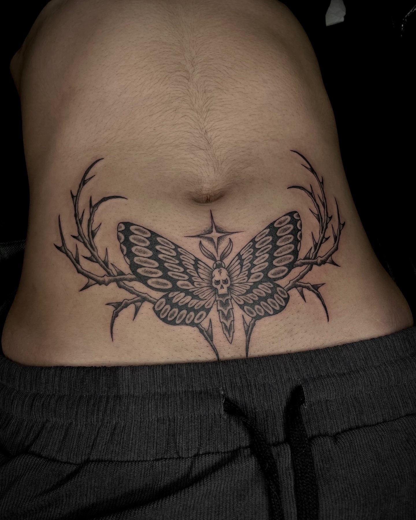 Butterfly with skull dark realism tattoo on the ribs by Tattoo Artist, in San Francisco, CA