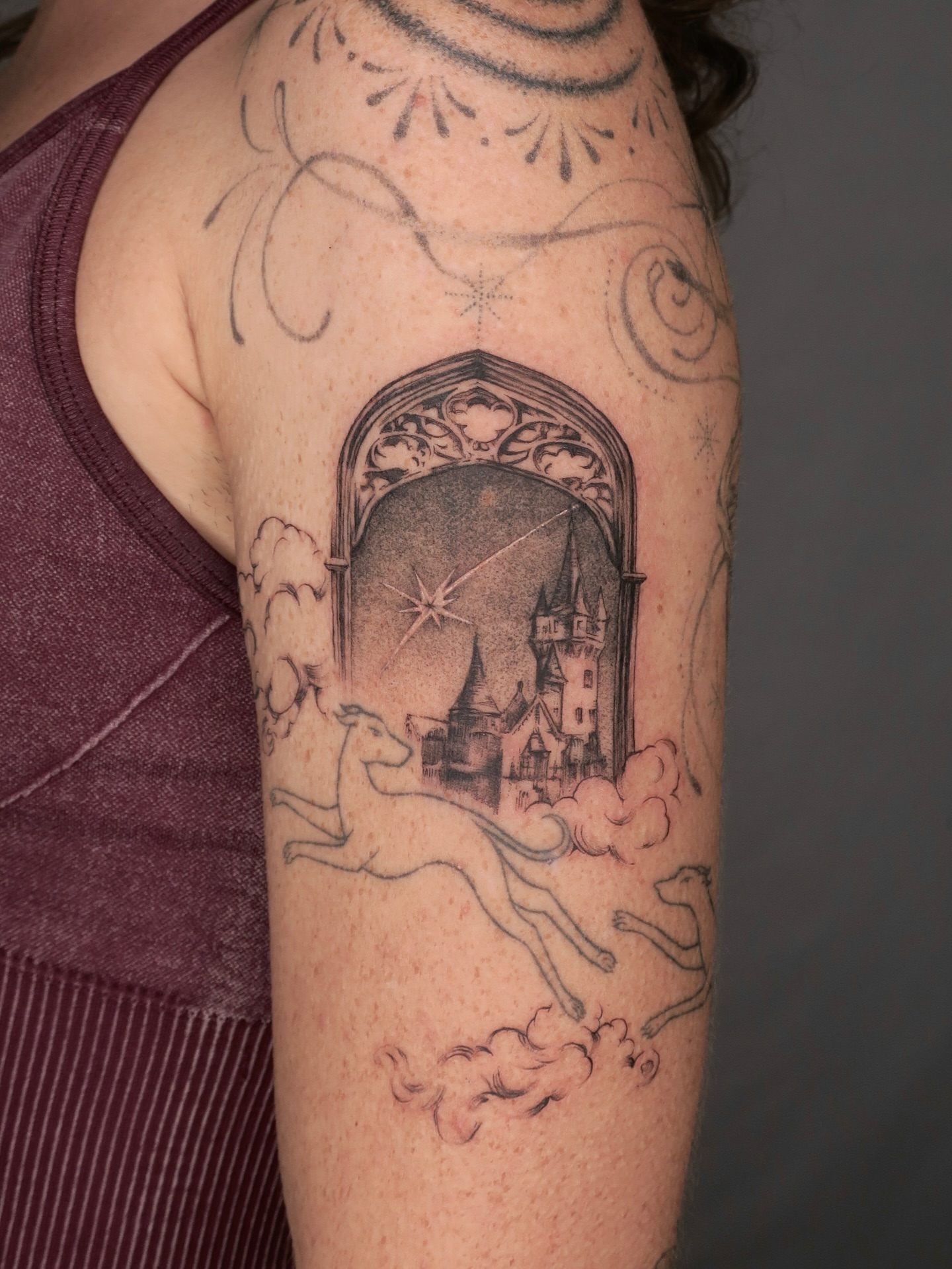 Castle and unicorn realism tattoo on the upper arm by Olivia