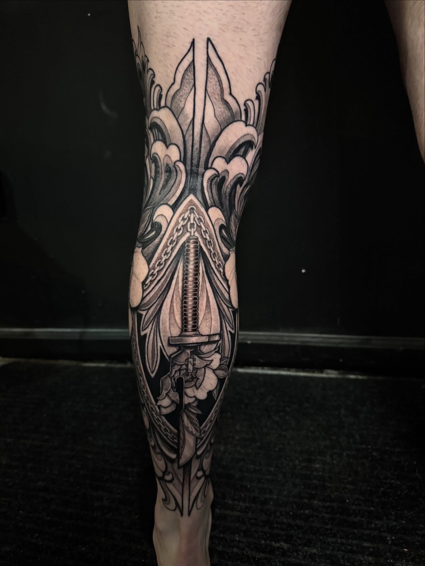 Sword and lotus geometric tattoo on the forearm by Caleb Gesicki