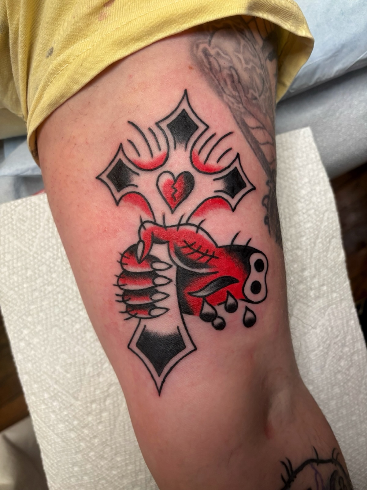Cross with heart American traditional tattoo on the forearm by Cooper Reichwein