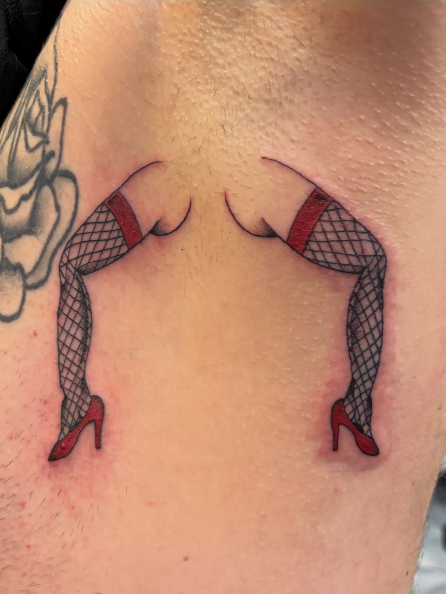 Legs in fishnet stockings American traditional tattoo on the shoulder by Miklo Montoya