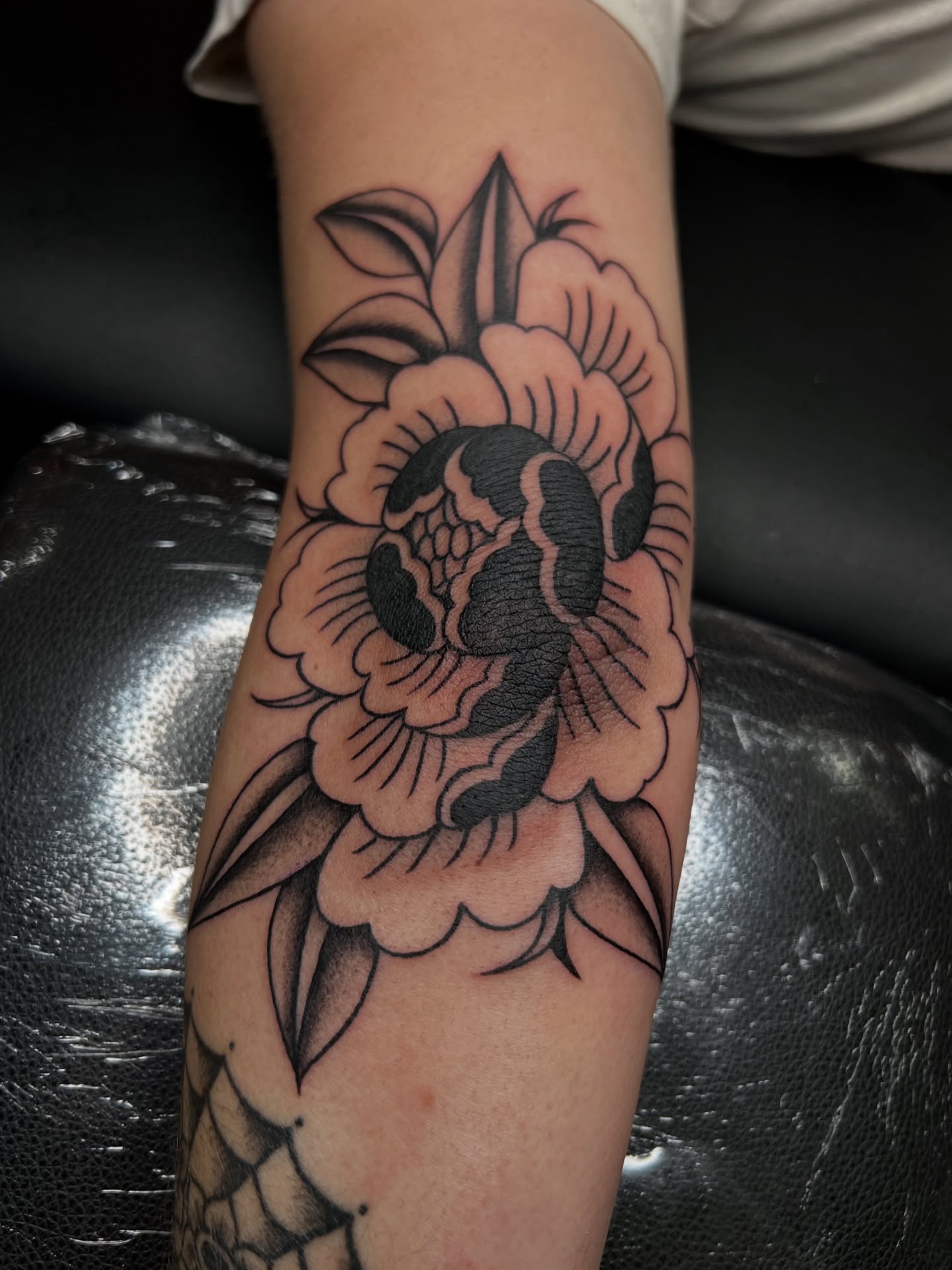 Snake and peony American traditional tattoo on the forearm by @syrenbier, San Francisco, California