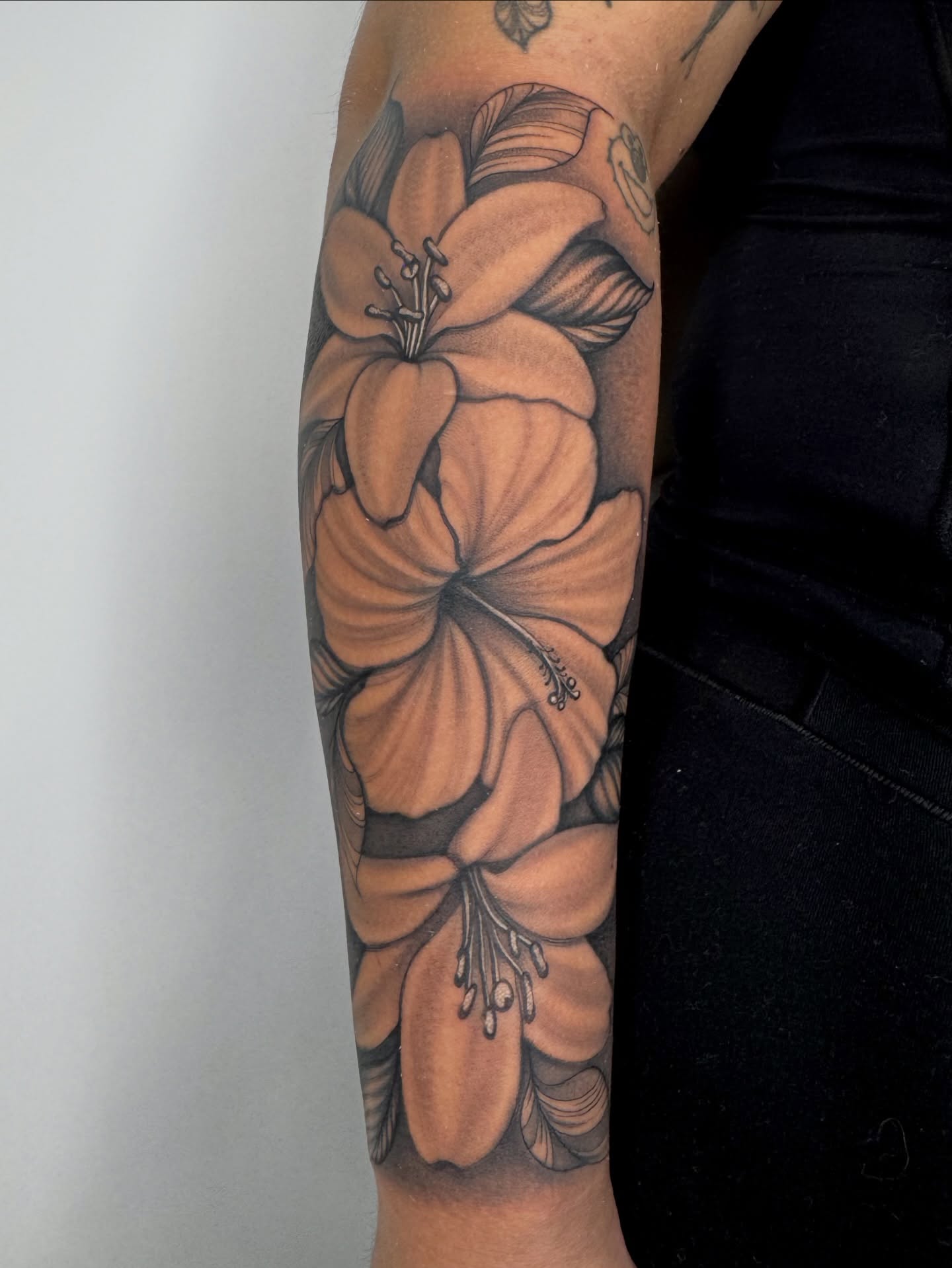 Hibiscus flowers black and grey tattoo on the forearm by Austin Tattoo Artist, Austin, Texas