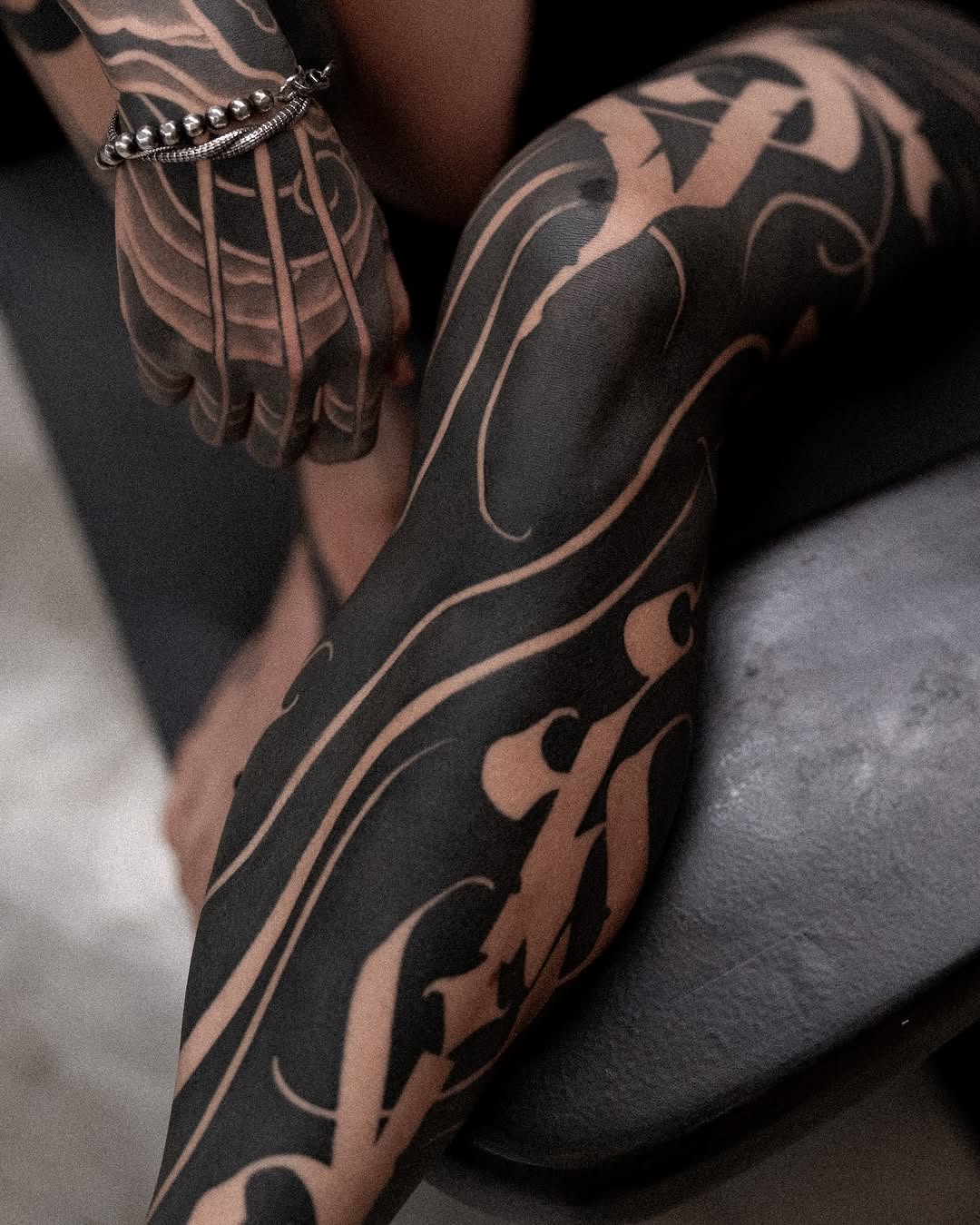 Ornamental script blackwork tattoo on the leg by Low, Brooklyn, New York