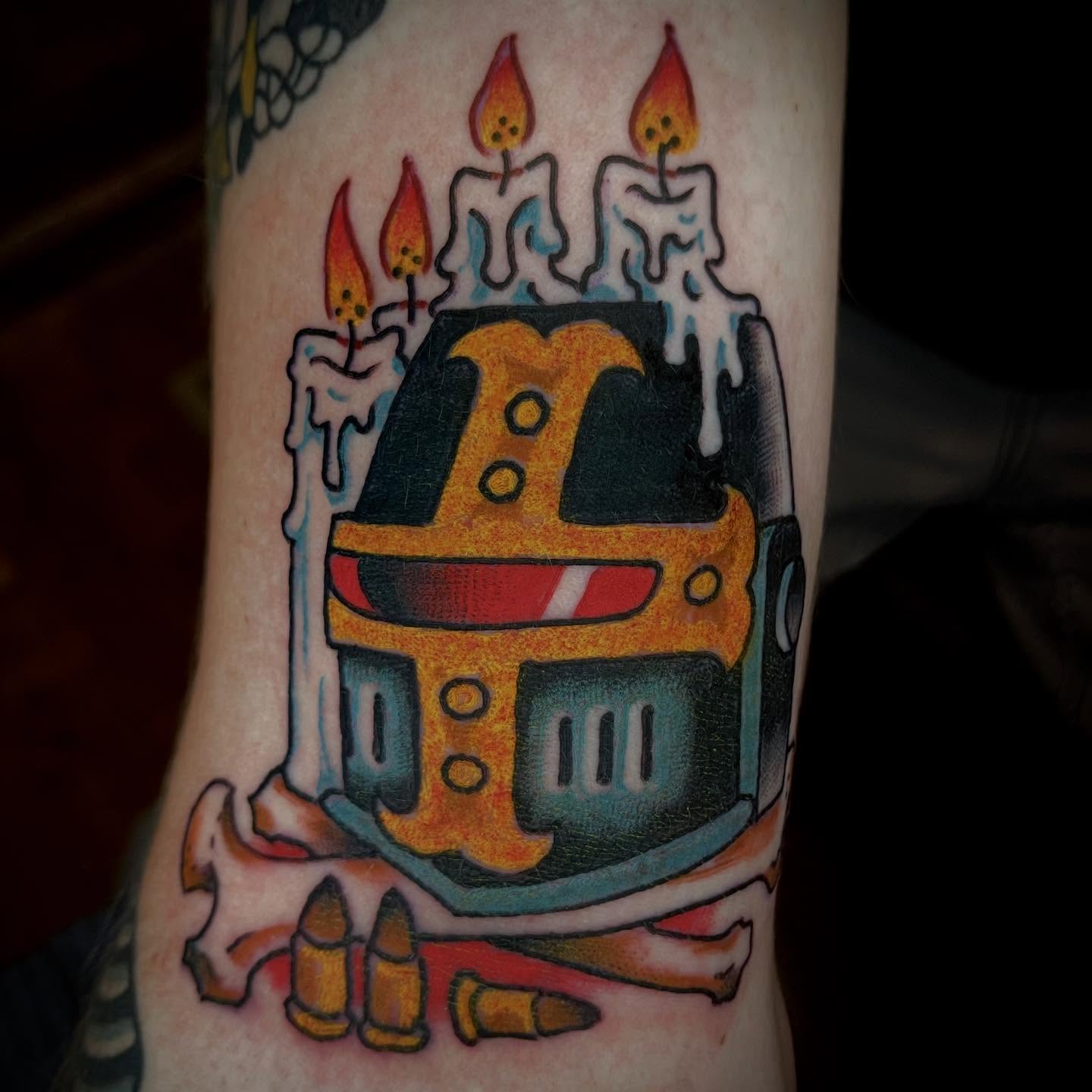 Robot helmet with candles American traditional tattoo on the forearm by Ian Bederman, Austin, Texas