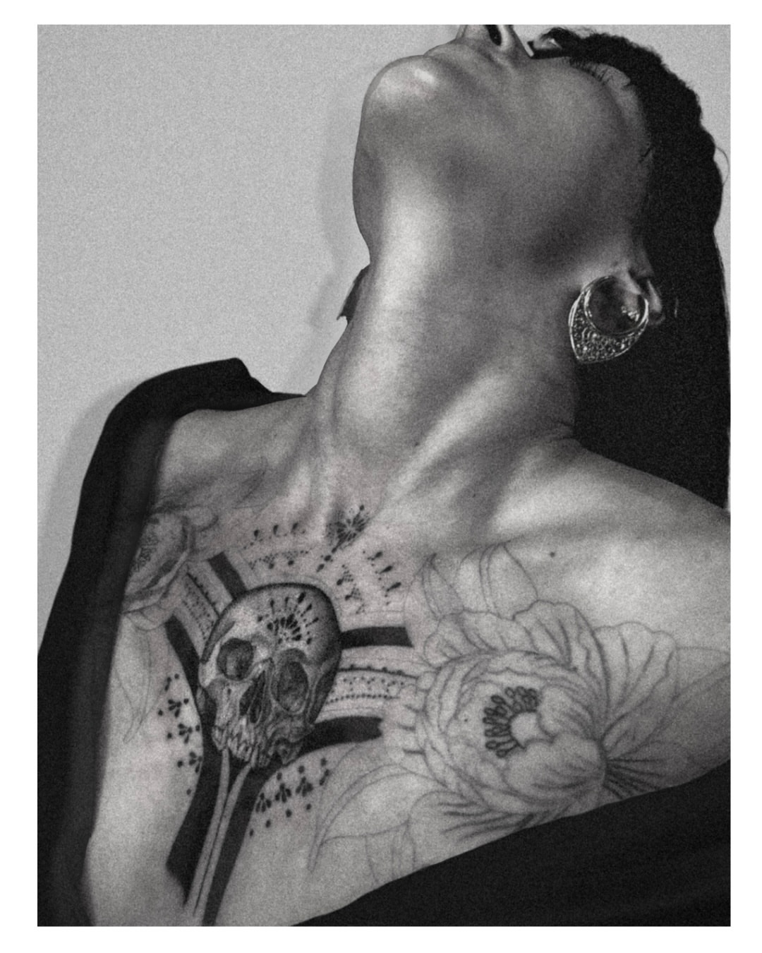 Skull and floral black and grey tattoo on the chest by Jordyn Tinney
