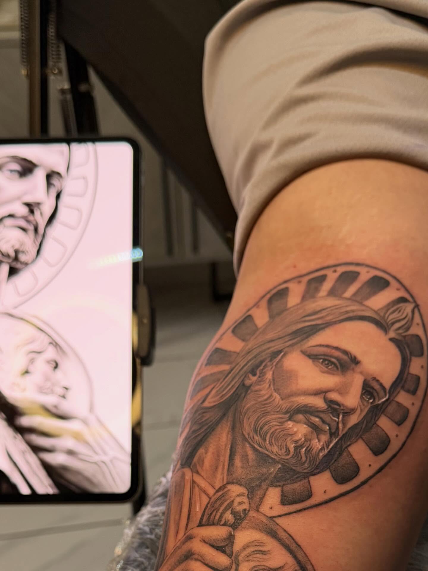 Religious figure black and grey tattoo on the thigh by Adrian gonzalez...