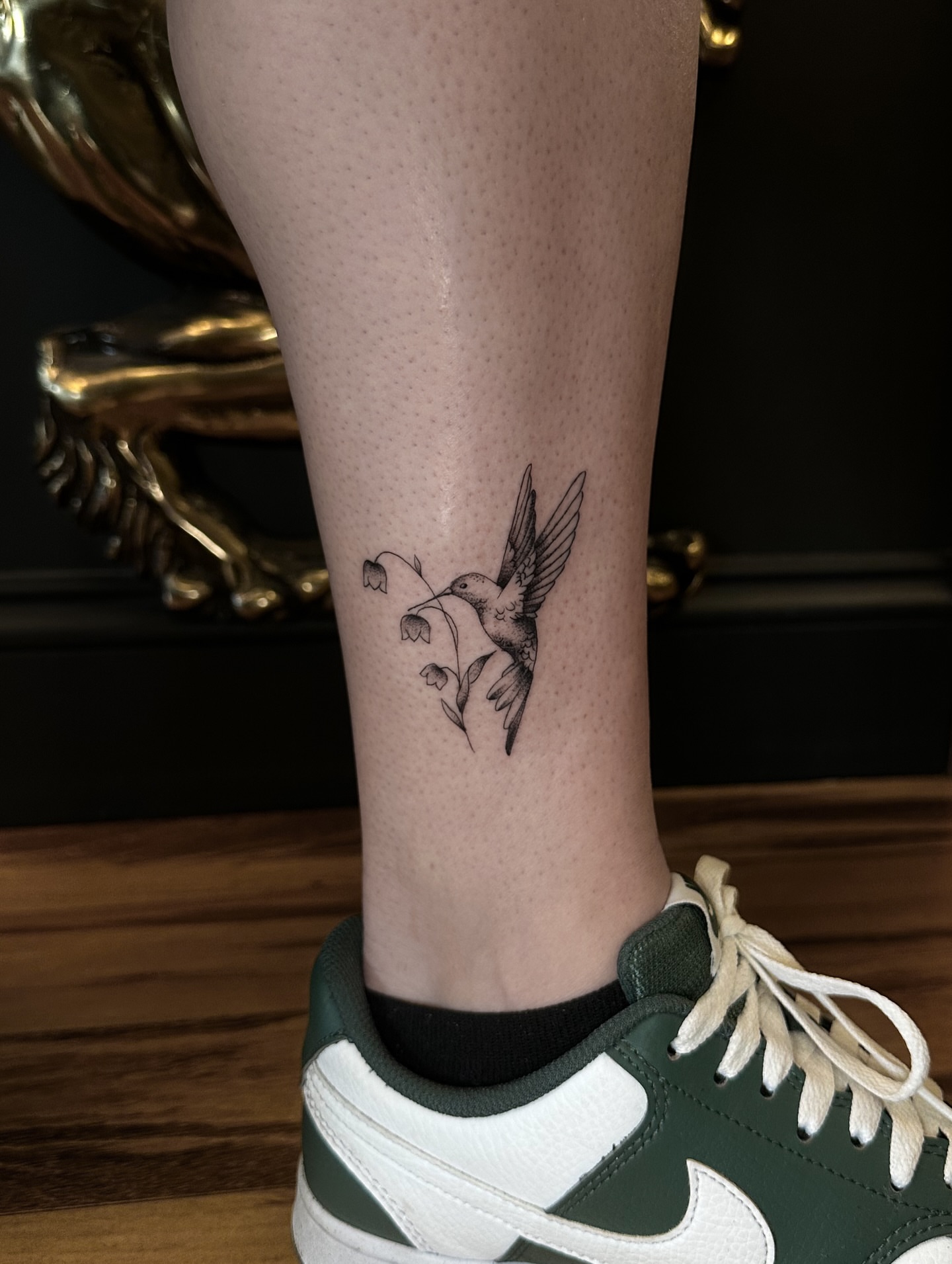 Hummingbird and flowers dotwork tattoo on the calf by Leo Fernandes, Danvers, Massachusetts