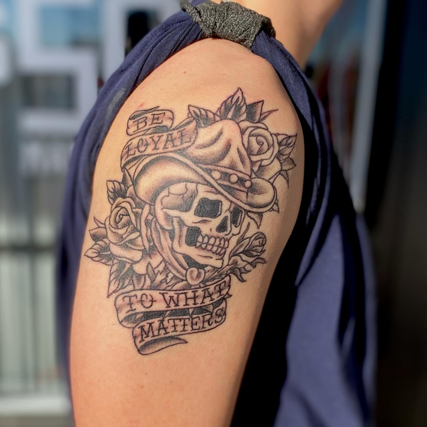 Skull with roses American traditional tattoo on the shoulder by Las Vegas Tattoo Artist