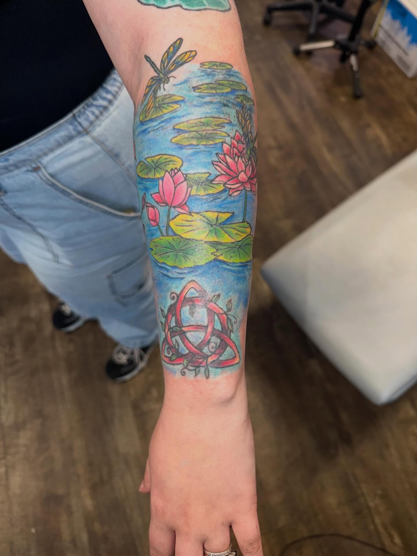 Water lilies and dragonfly new school tattoo on the forearm by Hope Powell, Vancouver, Washington