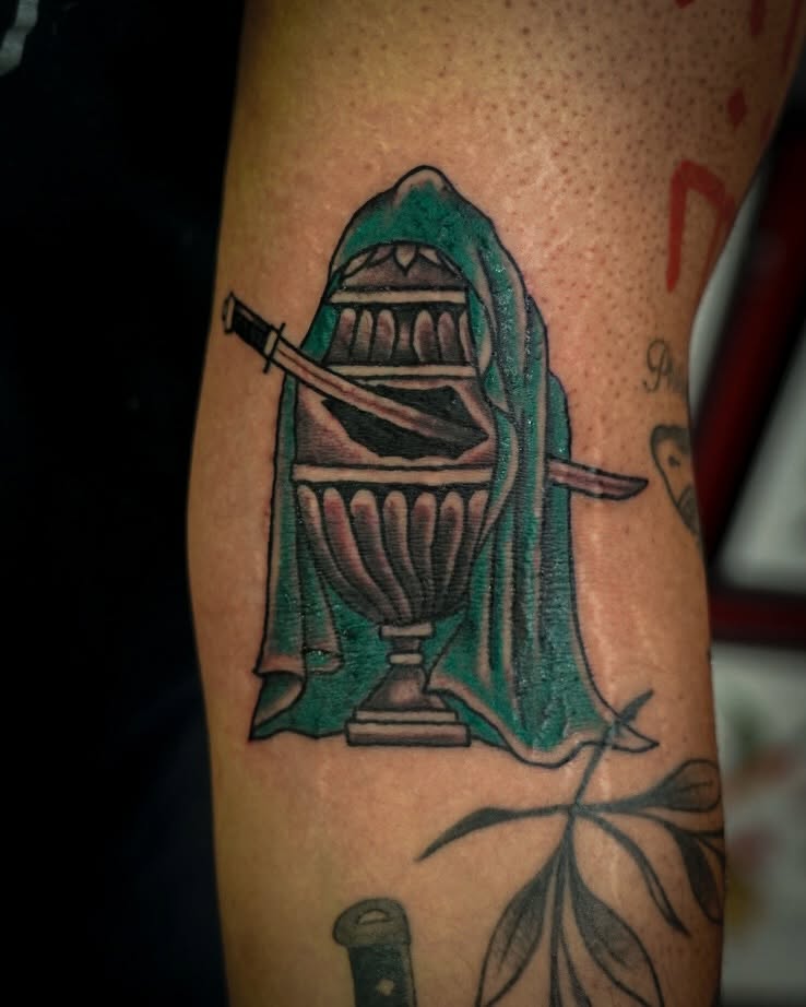 Hooded urn with swords neo-traditional tattoo on the forearm by Spicoli