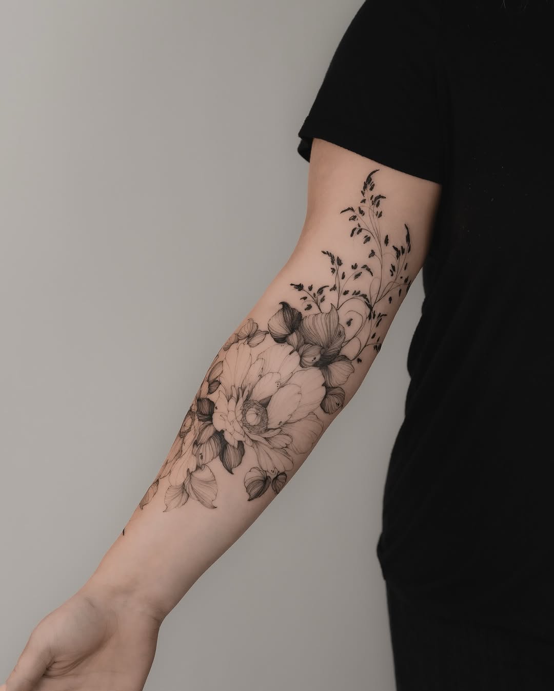 Floral arrangement with grass fine line tattoo on the forearm by Marek