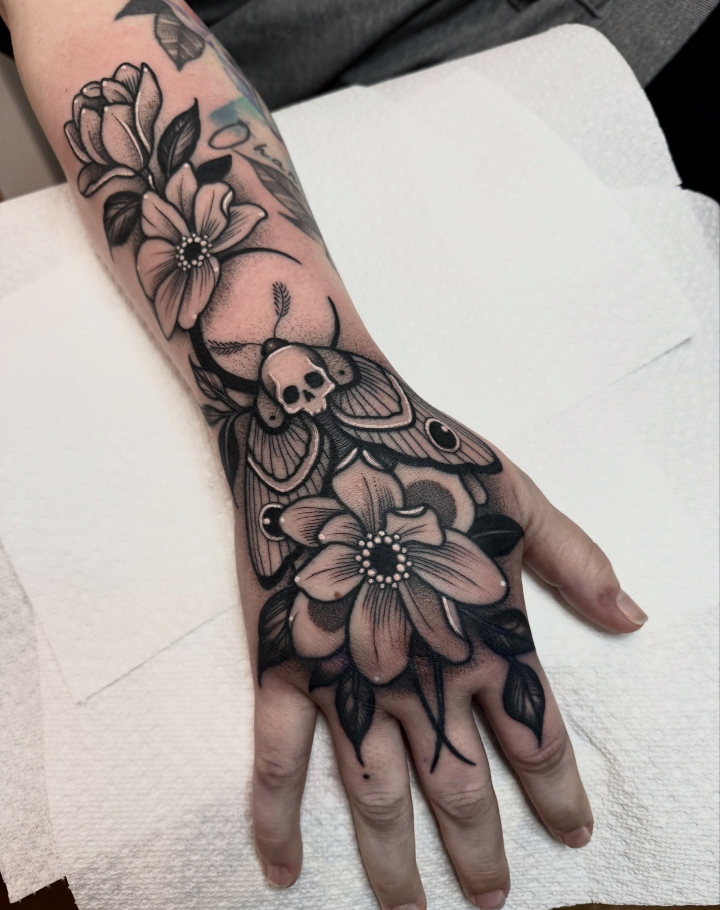 Flowers and moth black and grey tattoo on the hand by ⚡️ Krissy Fabis ⚡️