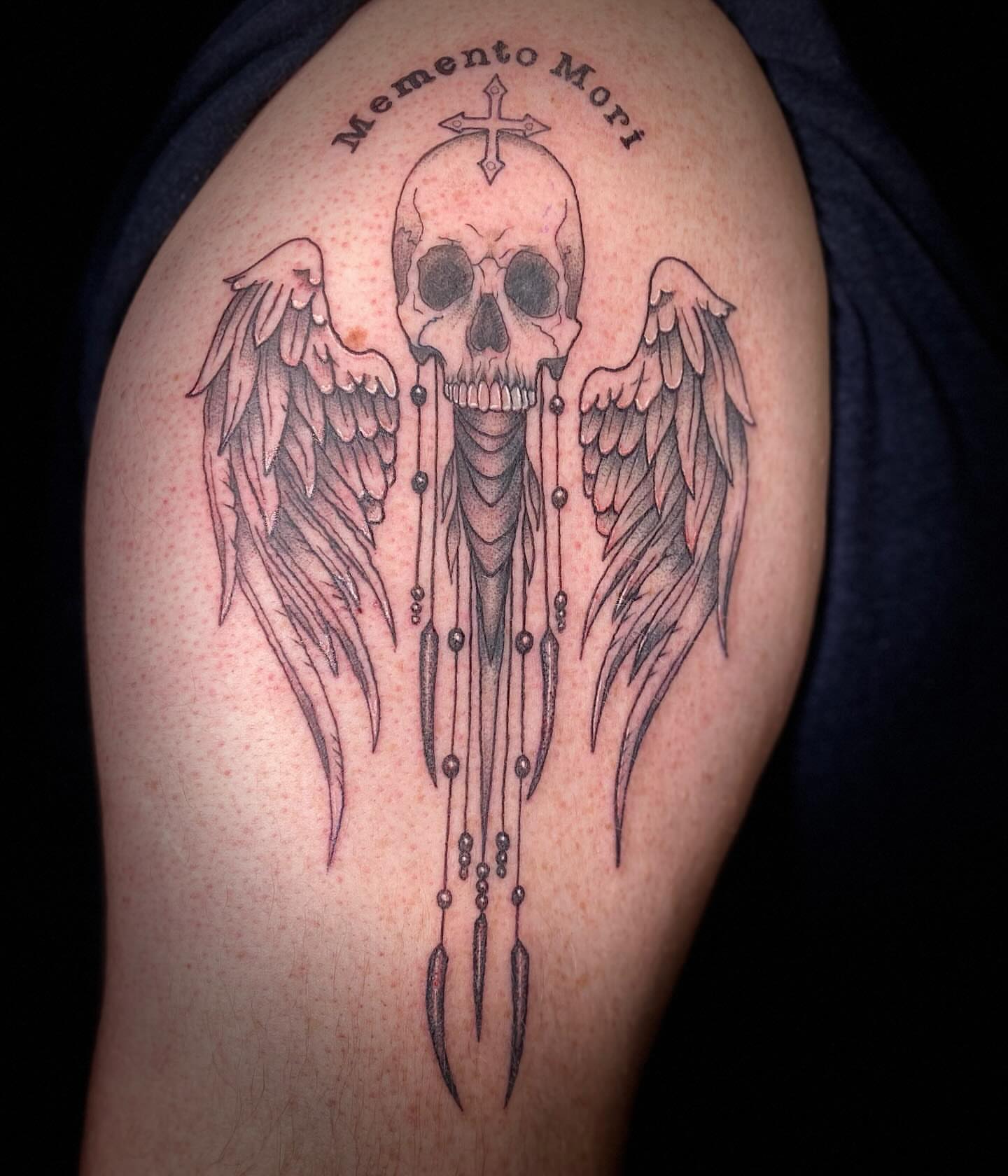 Skull with wings black and grey tattoo on the shoulder by Maddy Coletti✨