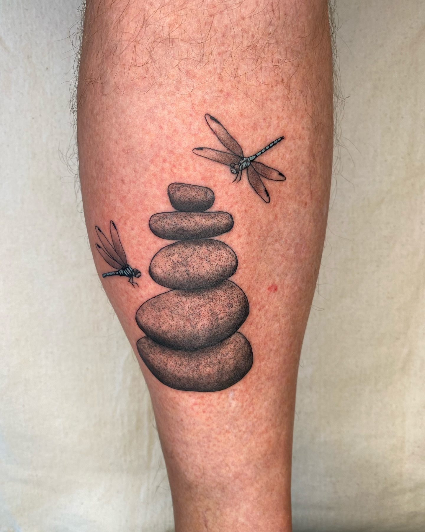 Stacked stones with dragonflies dotwork tattoo on the forearm by Sasha 🪆 Southern California Tattoo Artist