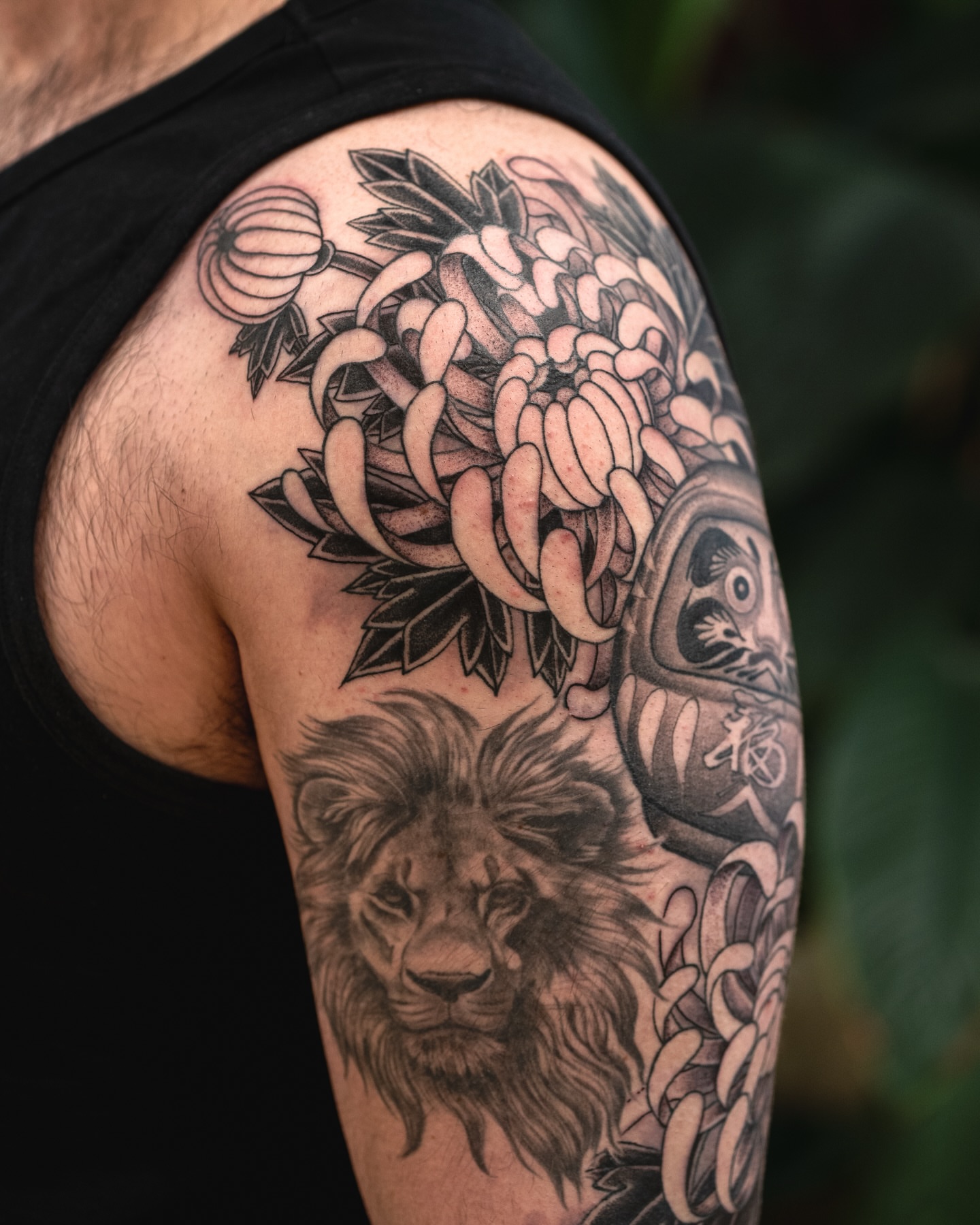 Lion and flowers realism tattoo on the upper arm by James Fernella, San Francisco, California