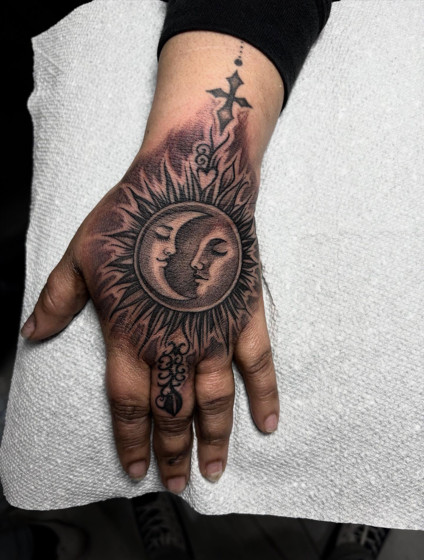 Sun and moon faces realism tattoo on the hand by Juan Lira