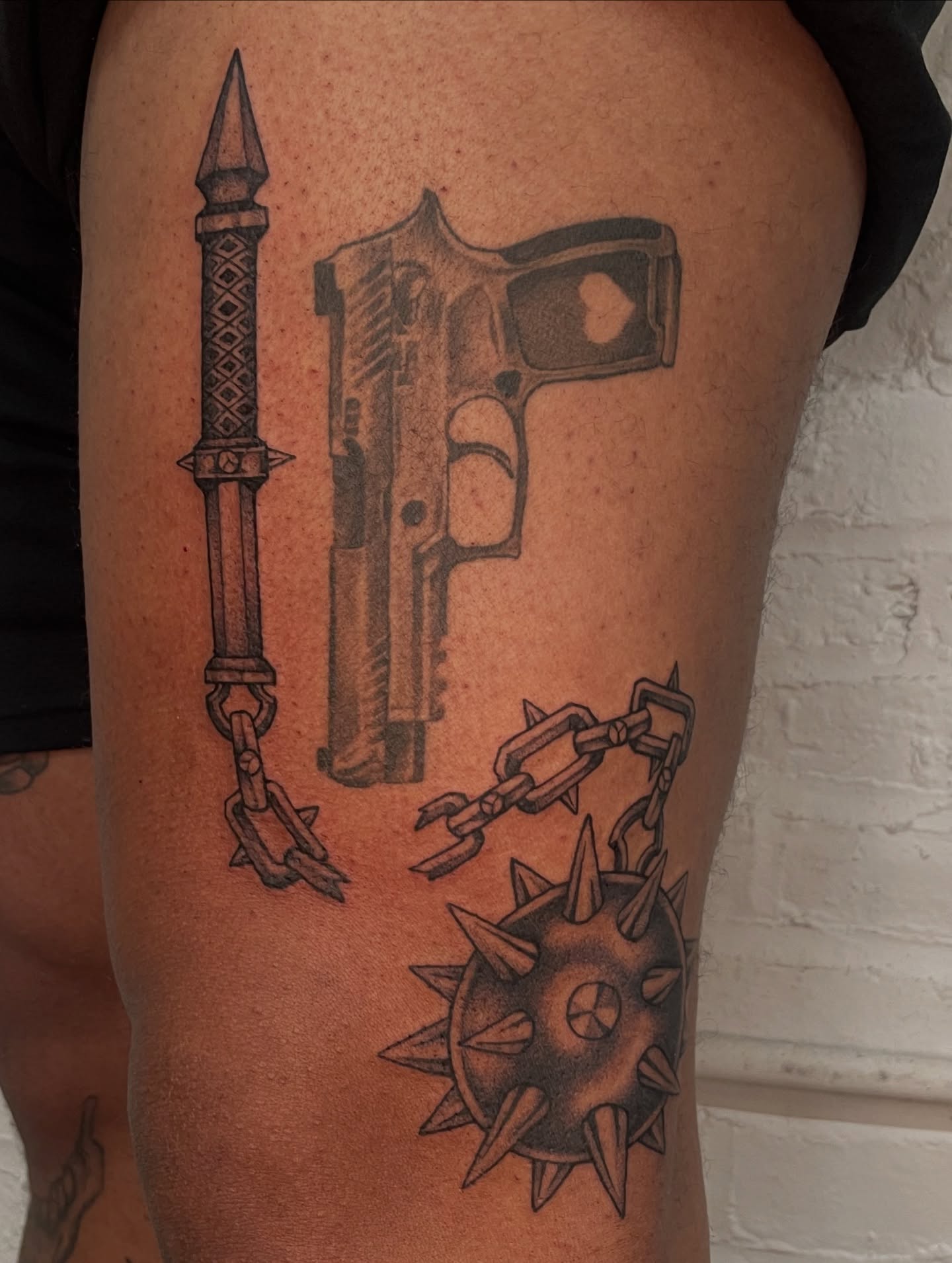 Gun and dagger black and grey tattoo on the thigh by Collie Mills, Philadelphia, Pennsylvania