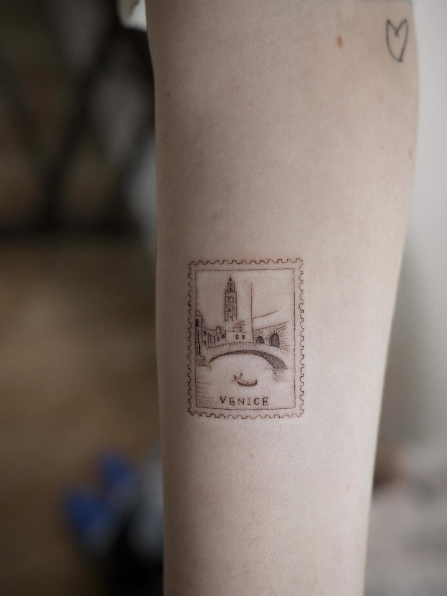 Venice stamp black and grey tattoo on the forearm by It’s ya girl, KB