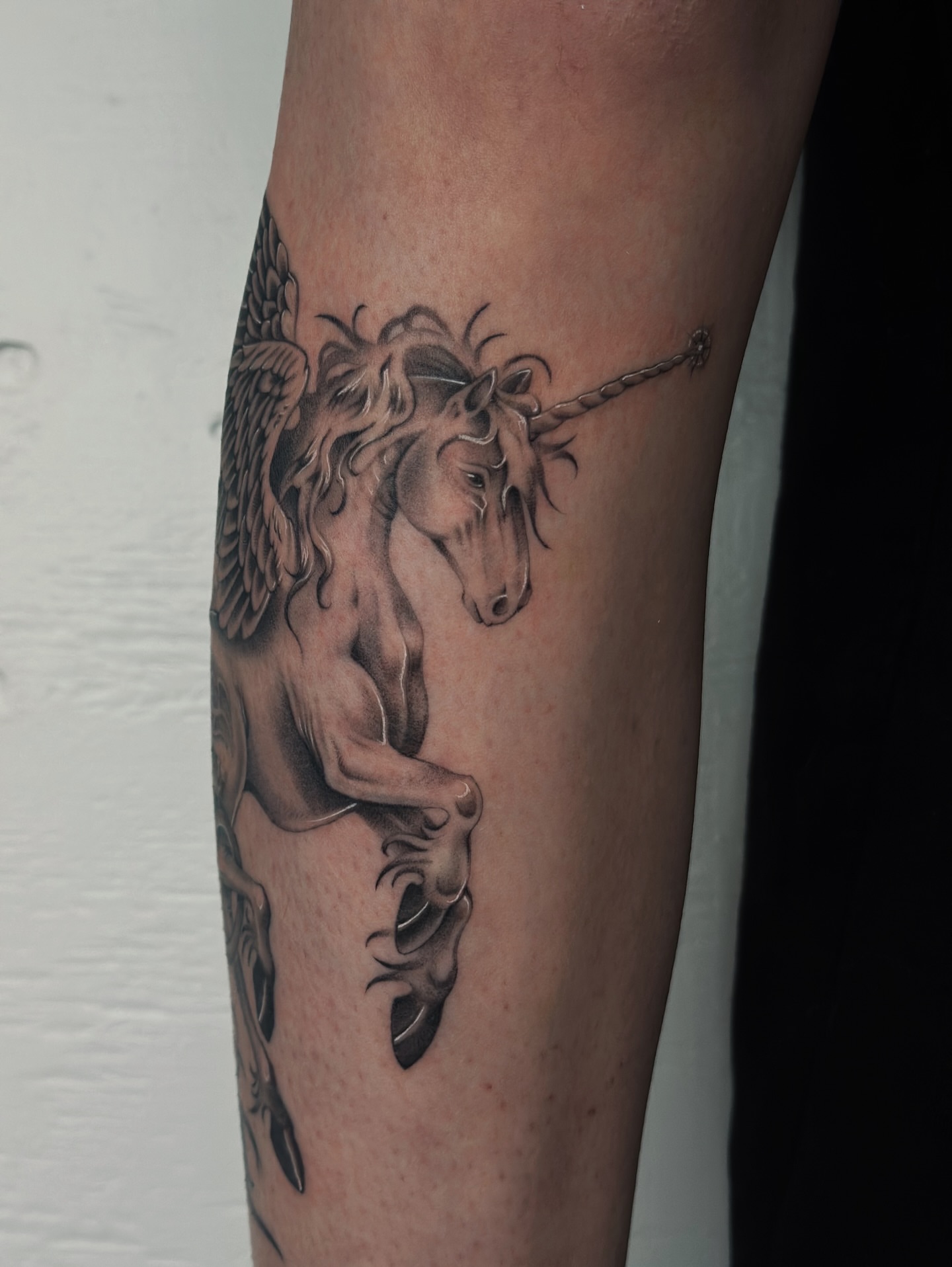 Unicorn black and grey tattoo on the forearm by Lauryn Jenesis