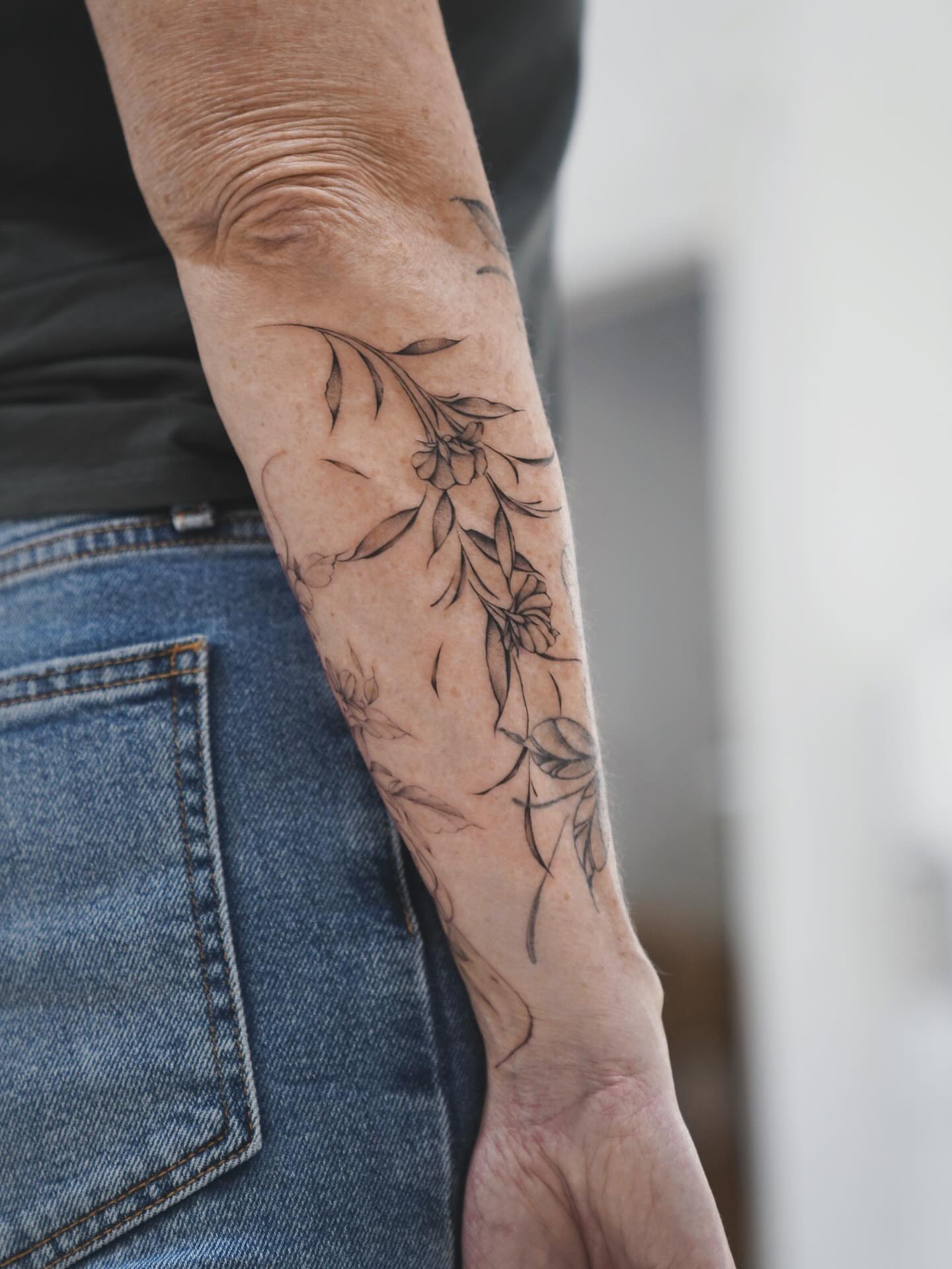 Floral design black and grey tattoo on the forearm by Raytattooist
