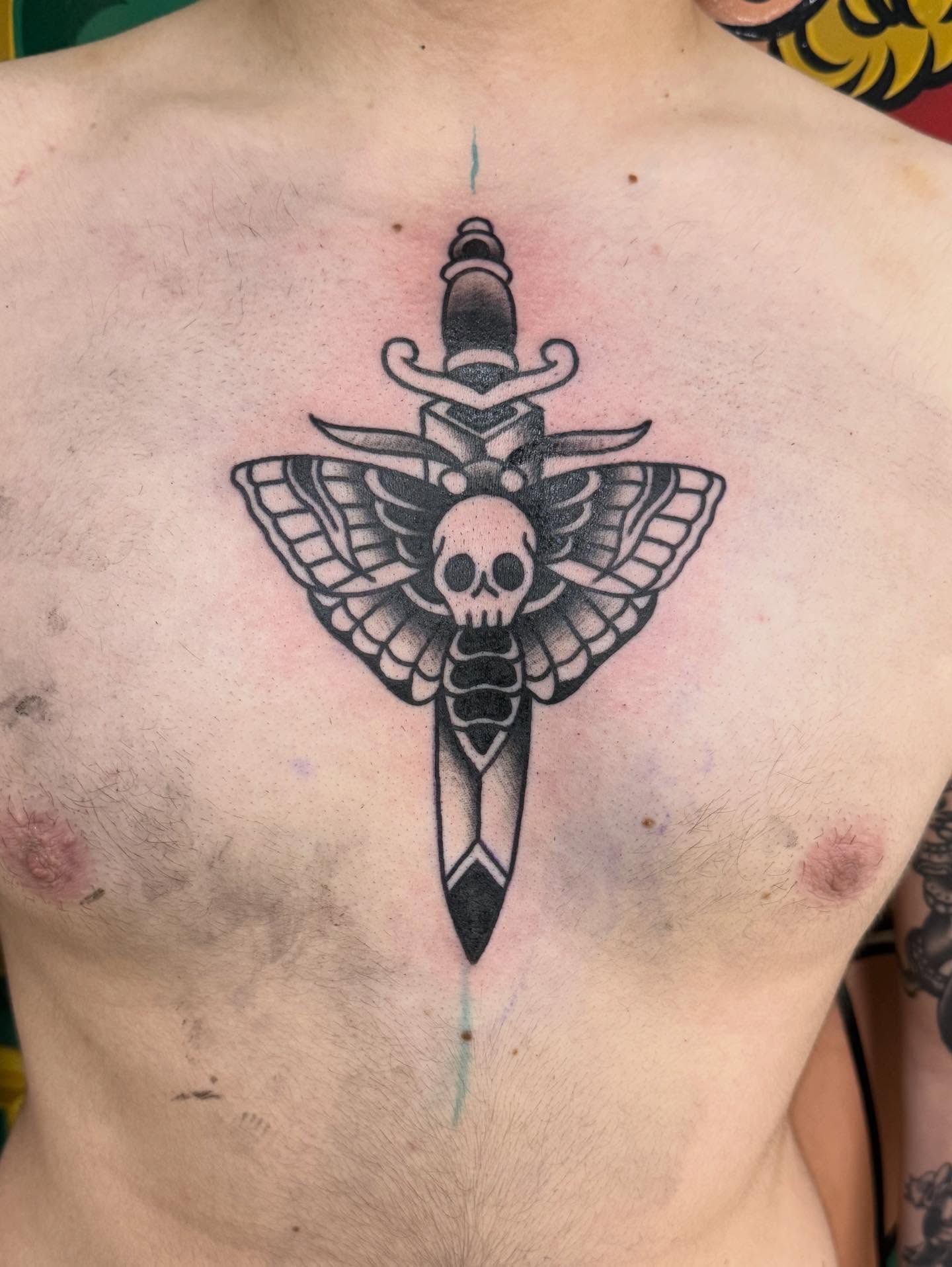 Moth and dagger black and grey tattoo on the chest by Jesse Coldiron