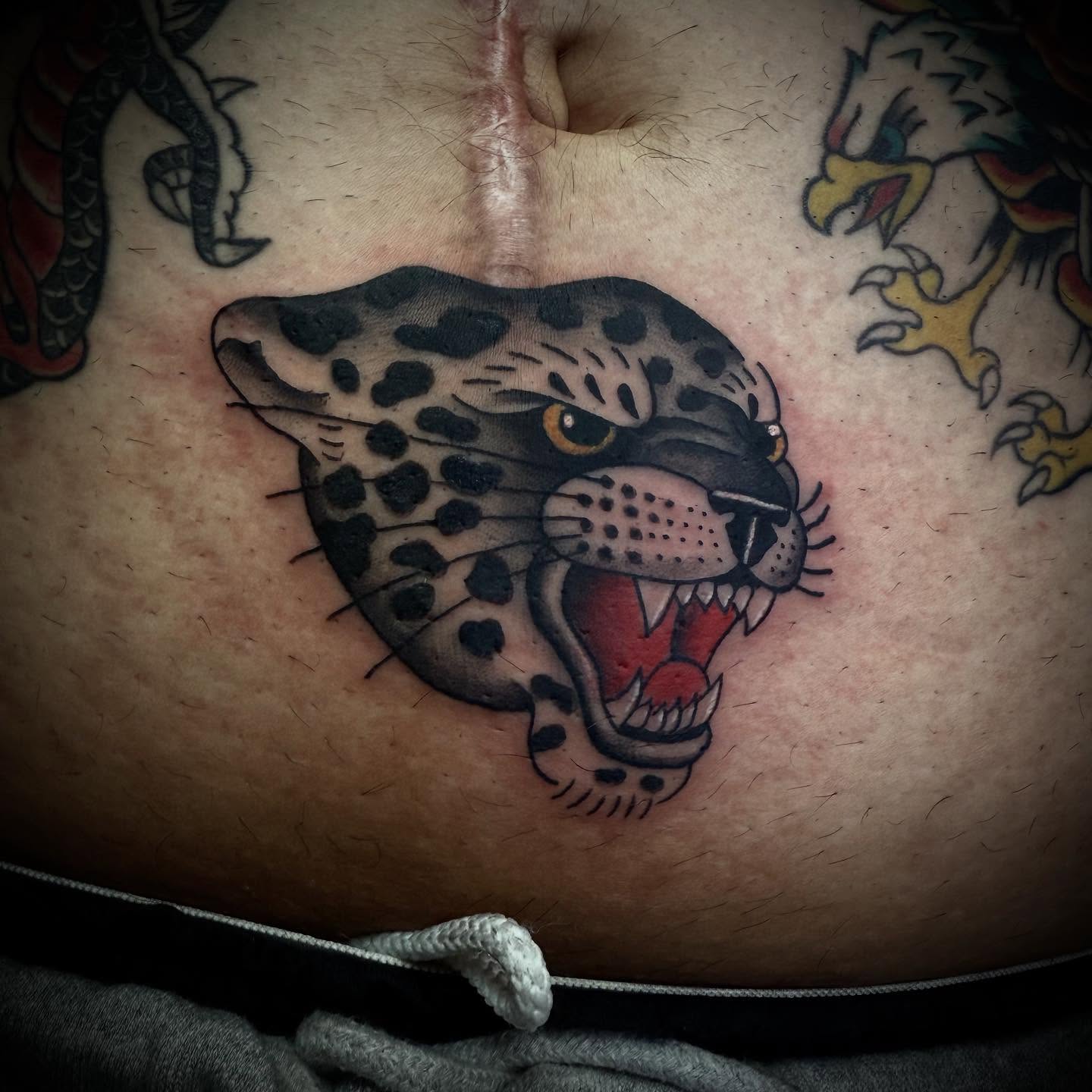 Snow leopard American traditional tattoo on the chest by Jameson William Cowan