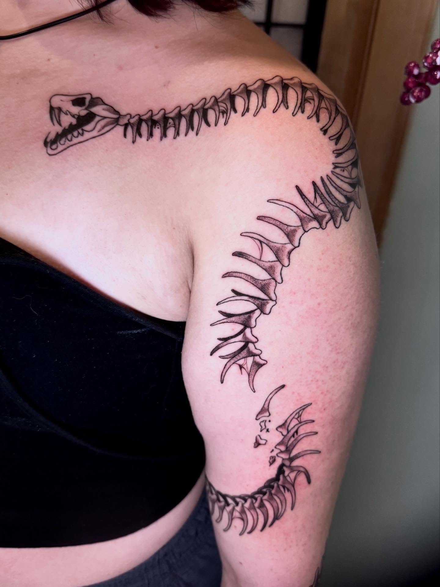 Snake skeleton black and grey tattoo on the shoulder by Morgan Peeples
