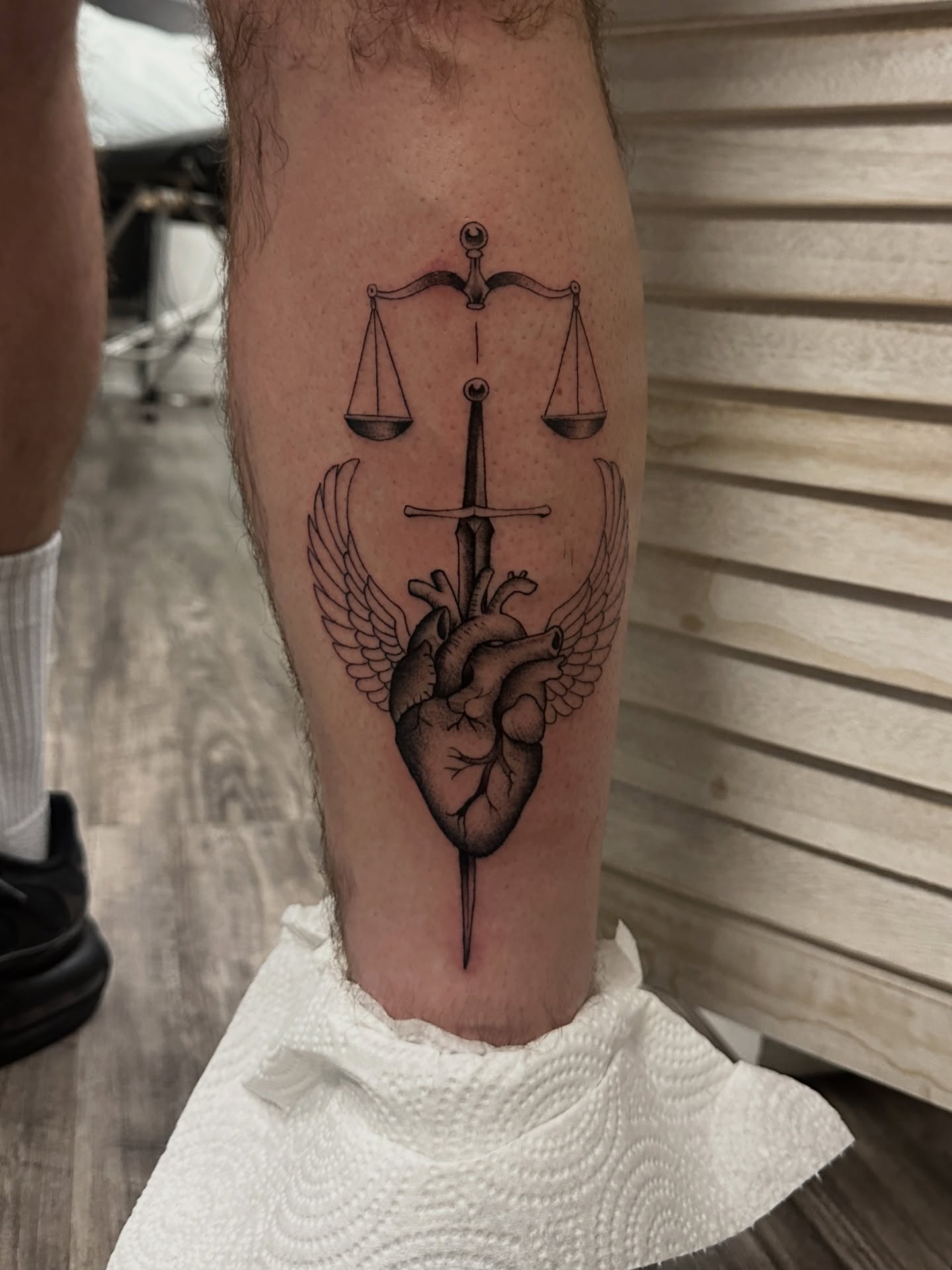 Heart with wings and sword realism tattoo on the forearm by Matt Kearney