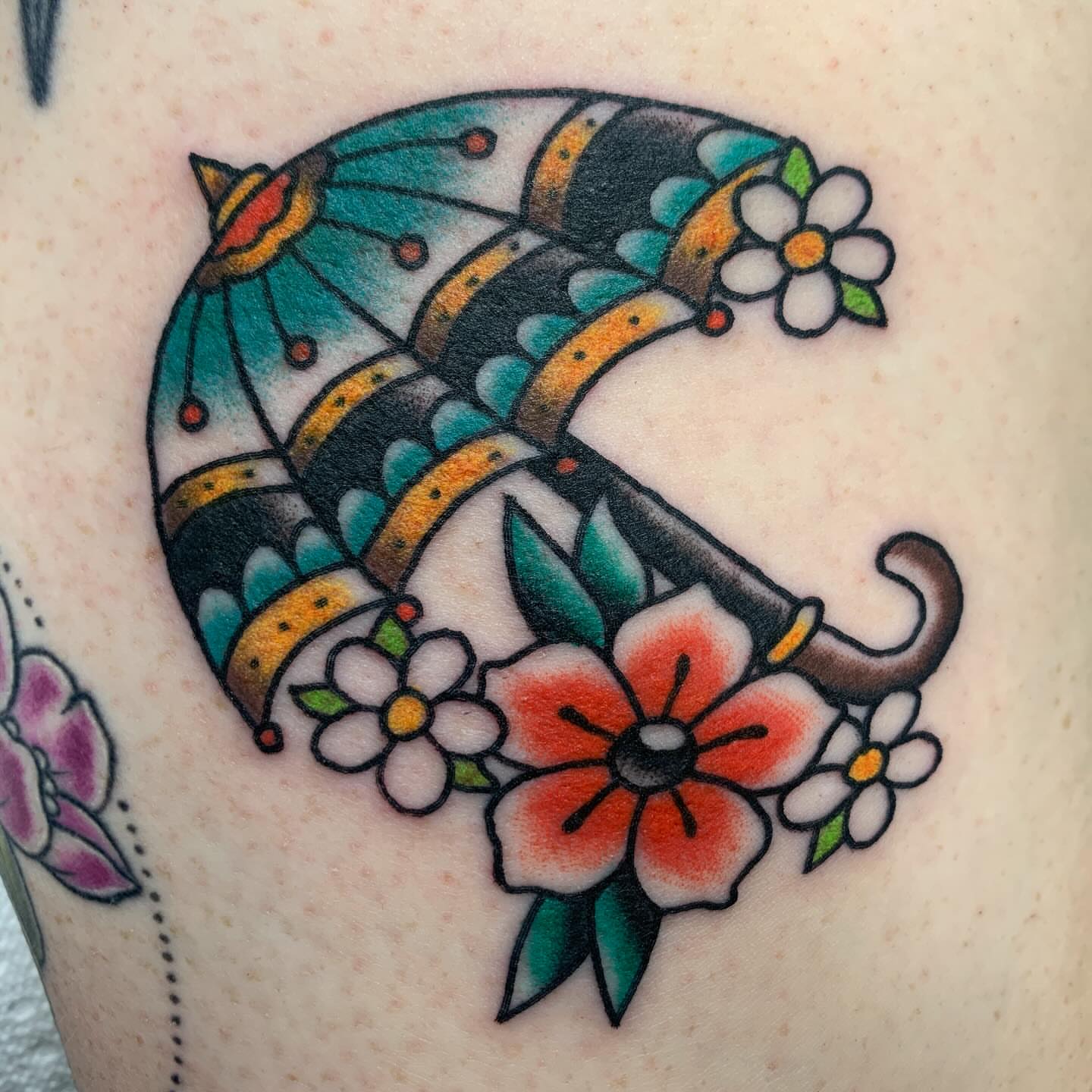 Umbrella and flowers American traditional tattoo on the thigh by April Morris ⚔️ Tattoo Goblin