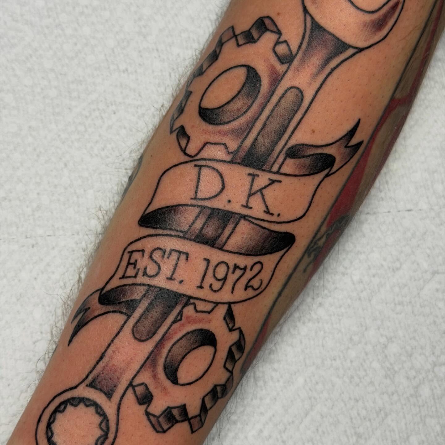 Mechanical gears and banner black and grey tattoo on the forearm by April Morris ⚔️ Tattoo Goblin