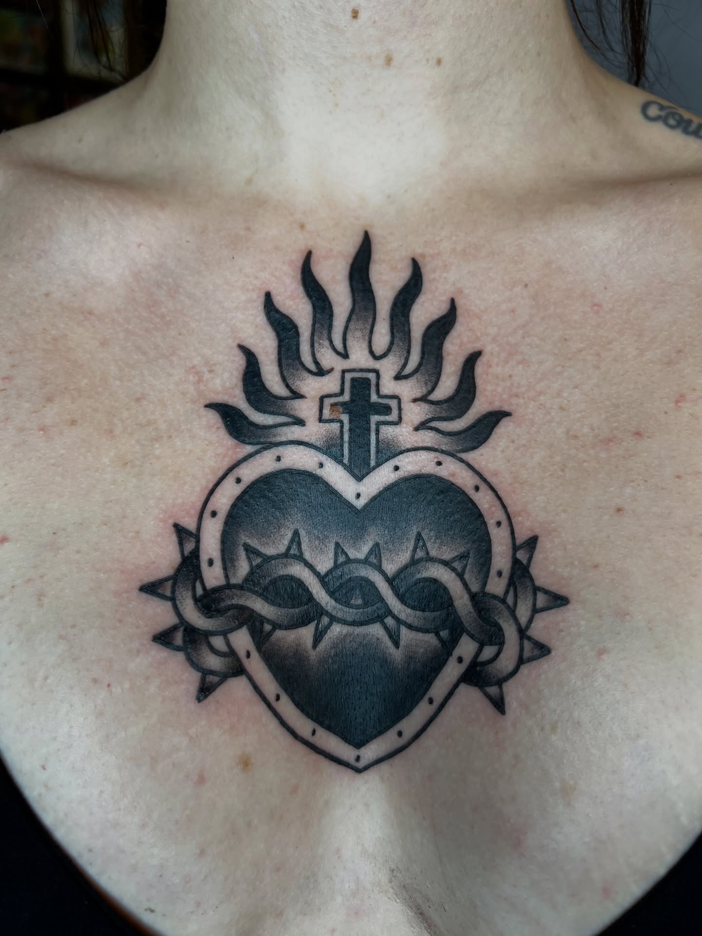 Heart with cross black and grey tattoo on the chest by Cory Miller