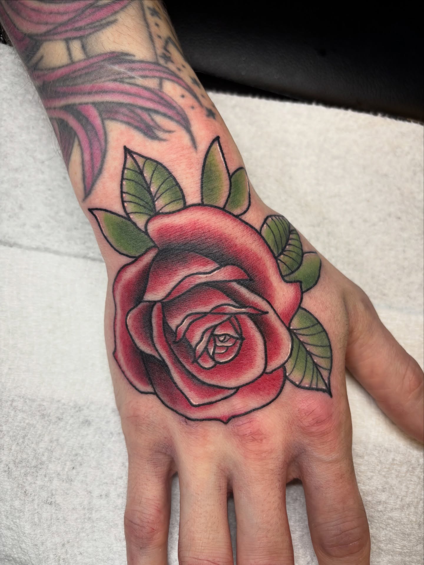 Rose American traditional tattoo on the hand by Malia Clark